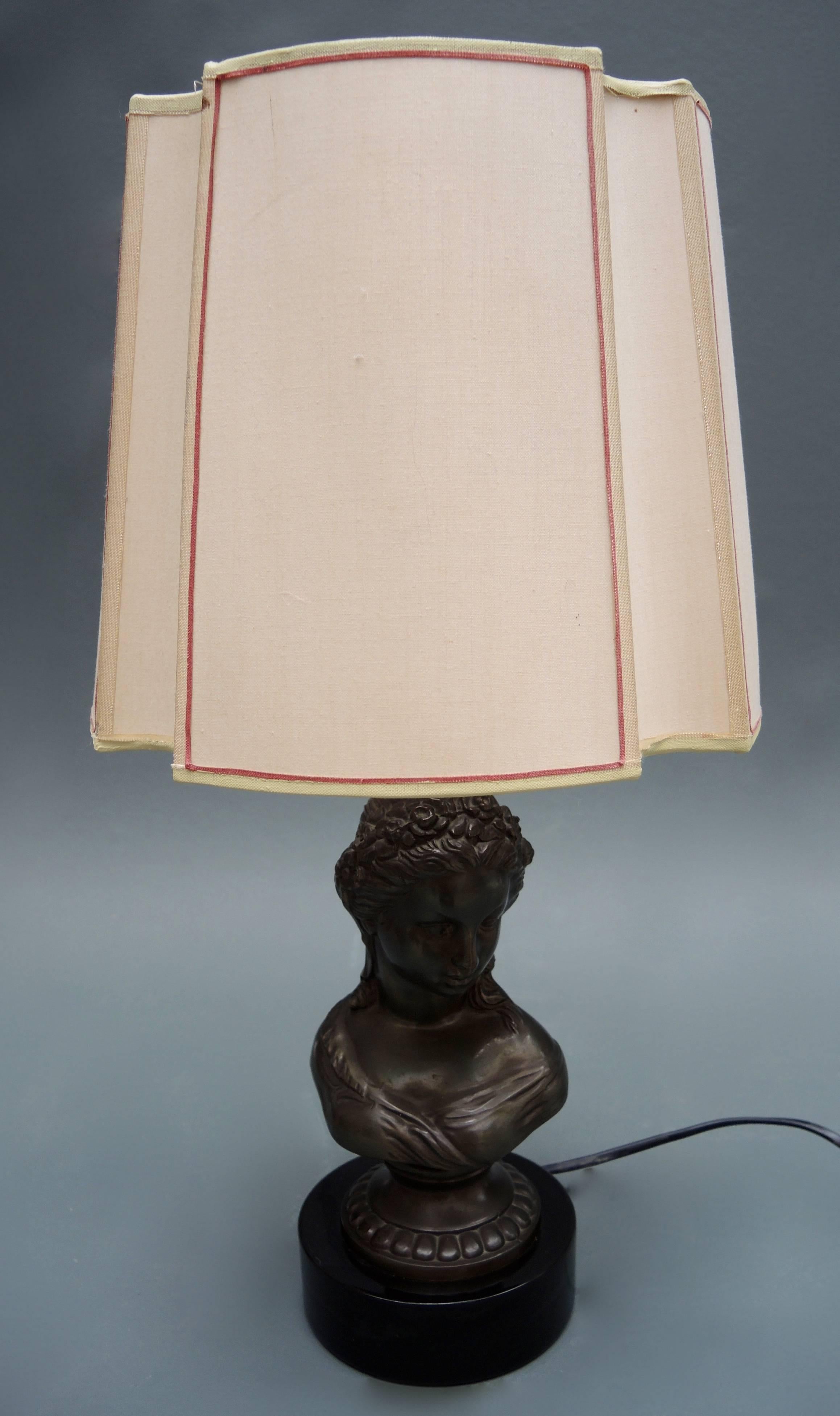 Lovely vintage table lamp cast metal bust of a young woman in the Louis XVI style mounted on a stone base. The lamp dates to the mid-20th century and includes the original unusually shaped handmade shade.
 
