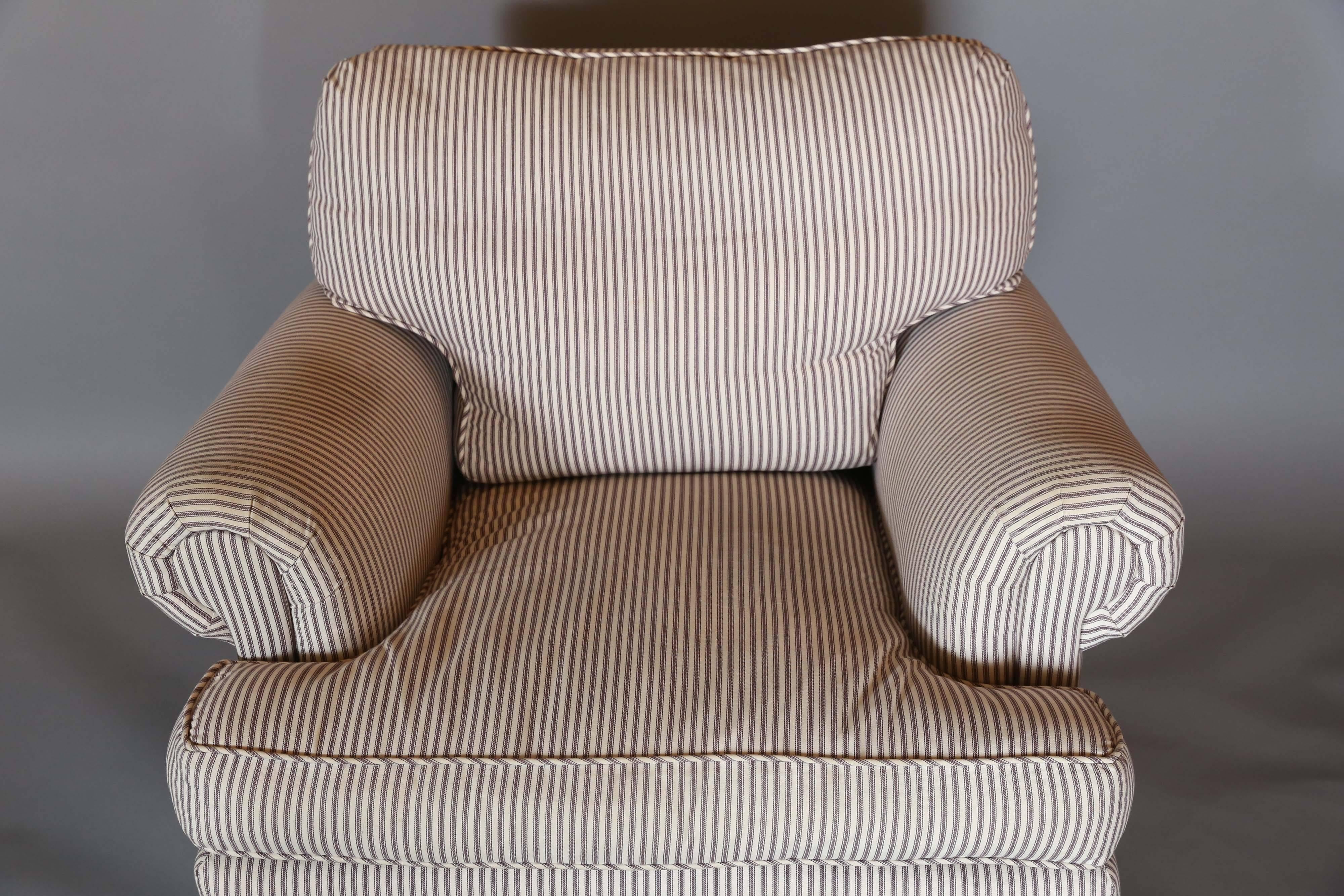 Very comfortable chair with matching ottoman upholstered in a simple purplish-brown ticking stripe. Upholstery detailed with stripe on diagonal for welting.

 