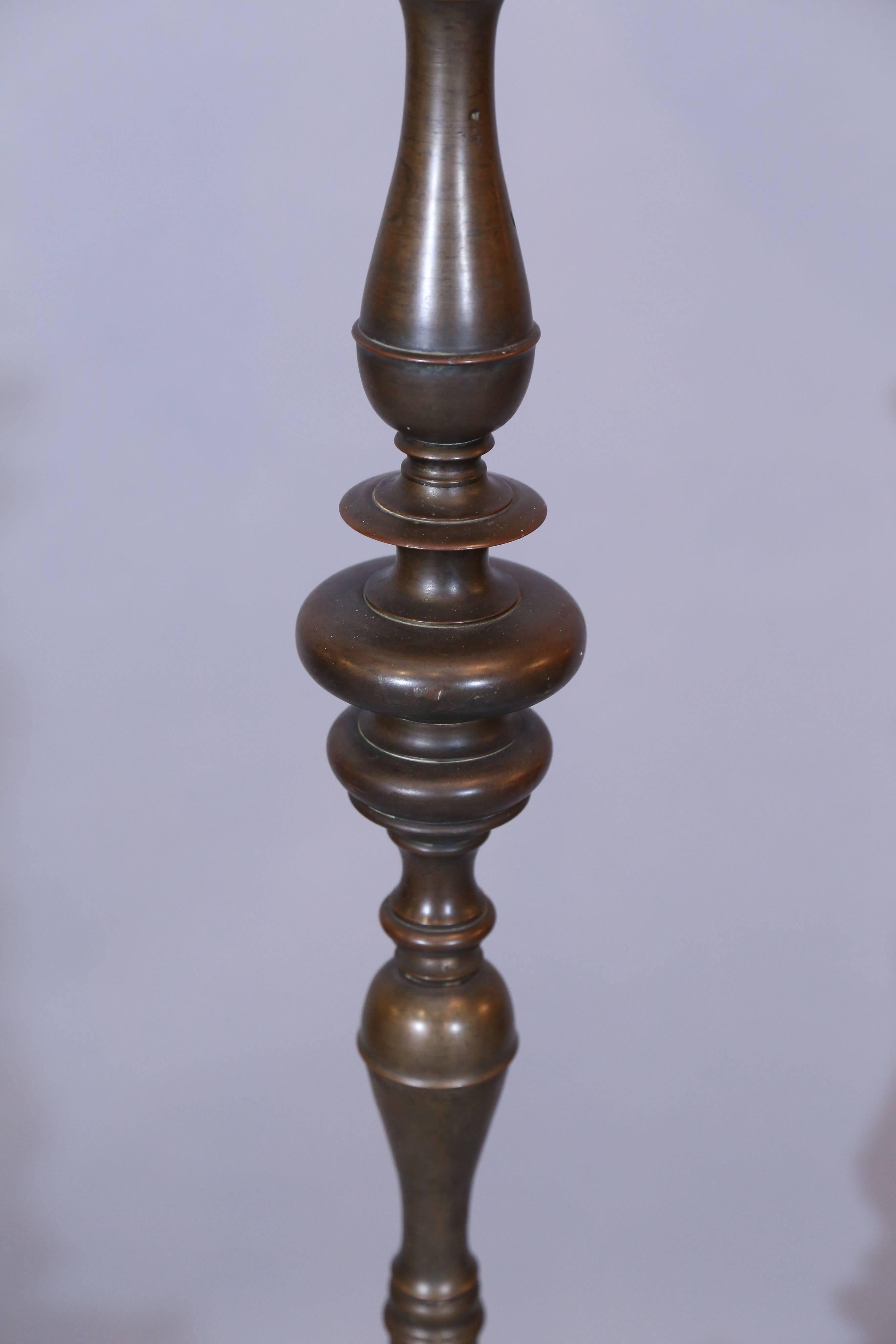 Baroque candlestick made of very heavy gauge bronze and sits upon an acanthus leaf wrought Iron tripod stand.

Candlestick has been converted to a lamp.