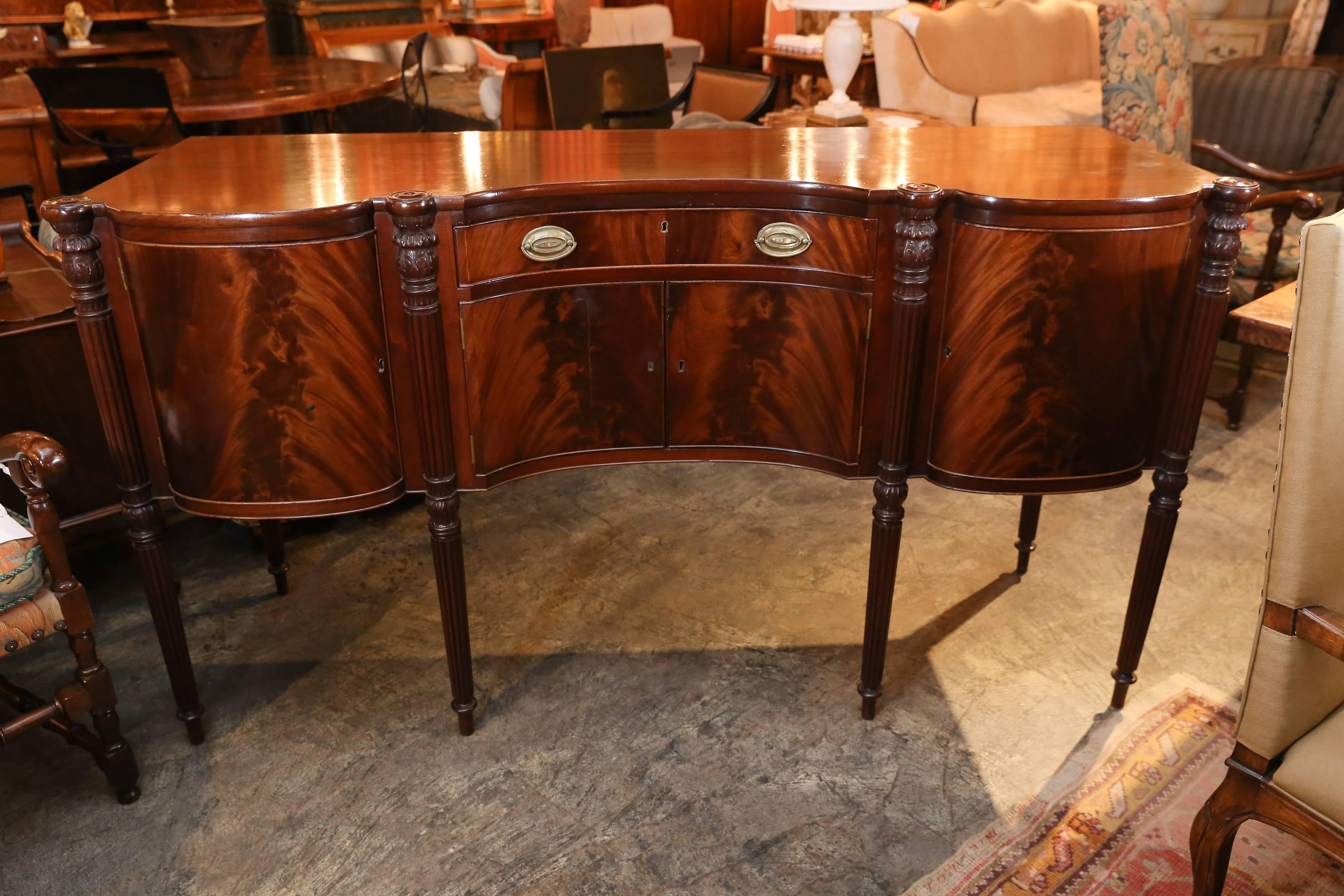 Tall 19th century English flame mahogany sideboard with centre silver drawer pair of doors below and doors at each end.

Legs are fluted and tapered.

 