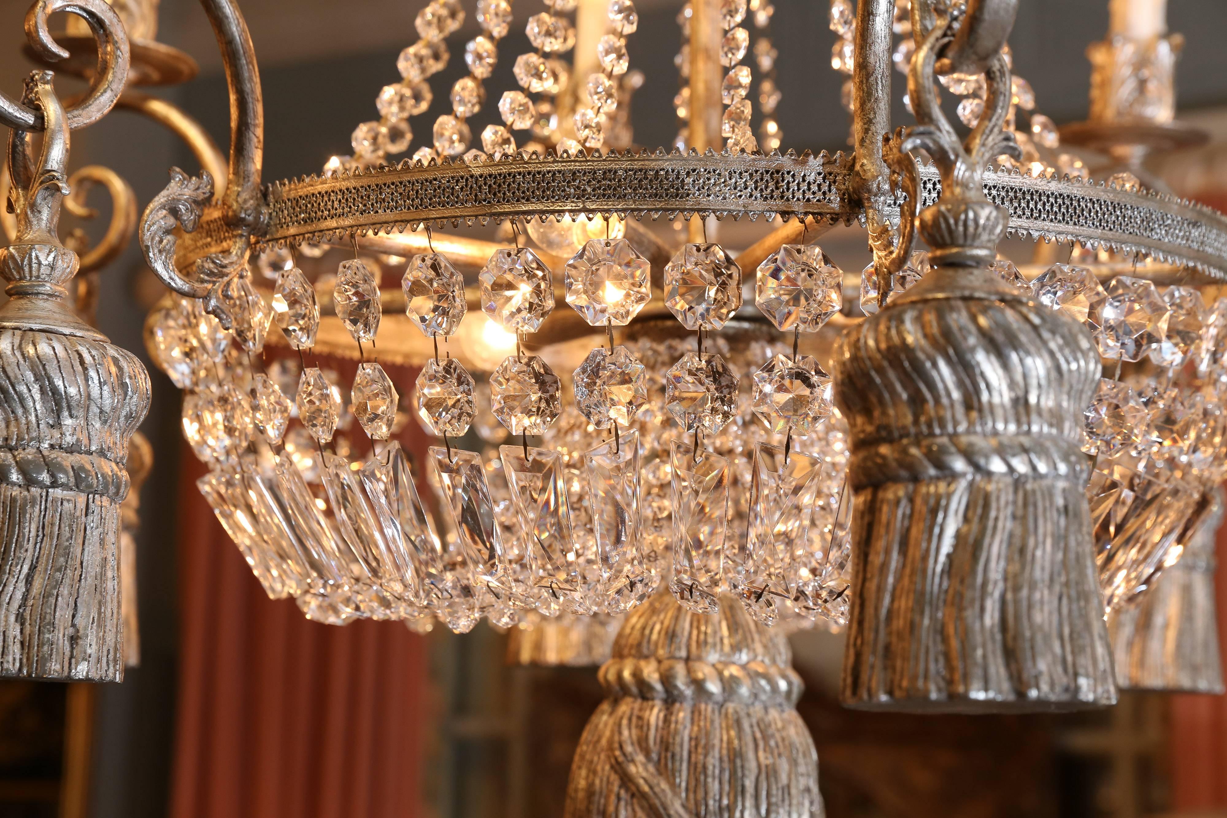 Beaded Empire style chandelier. All of the brass on chandelier is painted in a silver gilt finish, as well as wood- carved oversized tassels, which add a bit of whimsy to this piece.

Pair of bands on chandelier are pierced.

Silver gilt