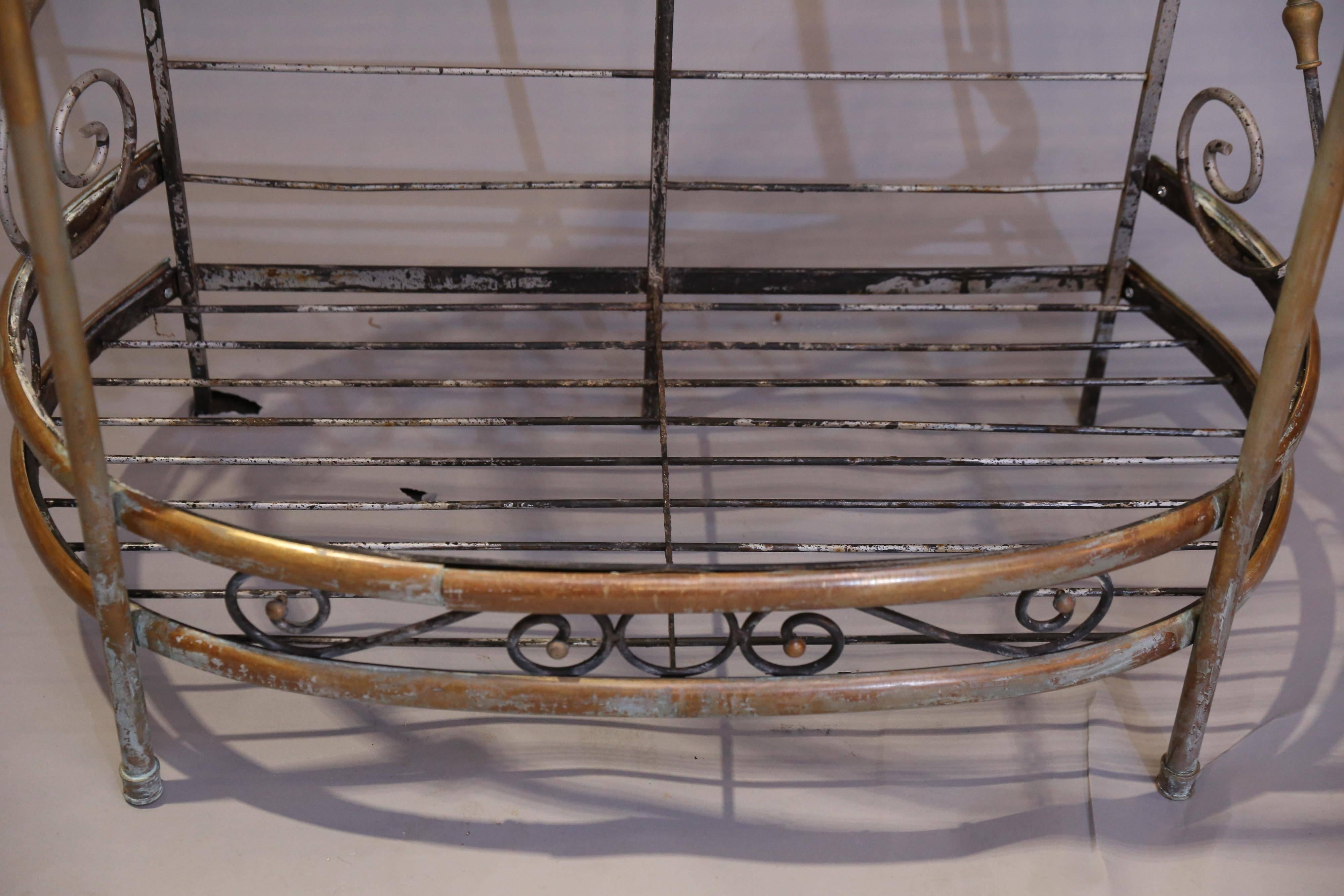 Wrought iron and brass Baker's rack has a curved front with brass fronts and finials to each of three shelves
Shelves are held up with an S-shaped bracket with brass ornamentation.
At the very top of Baker's rack is a wheat sheaf, adding to the
