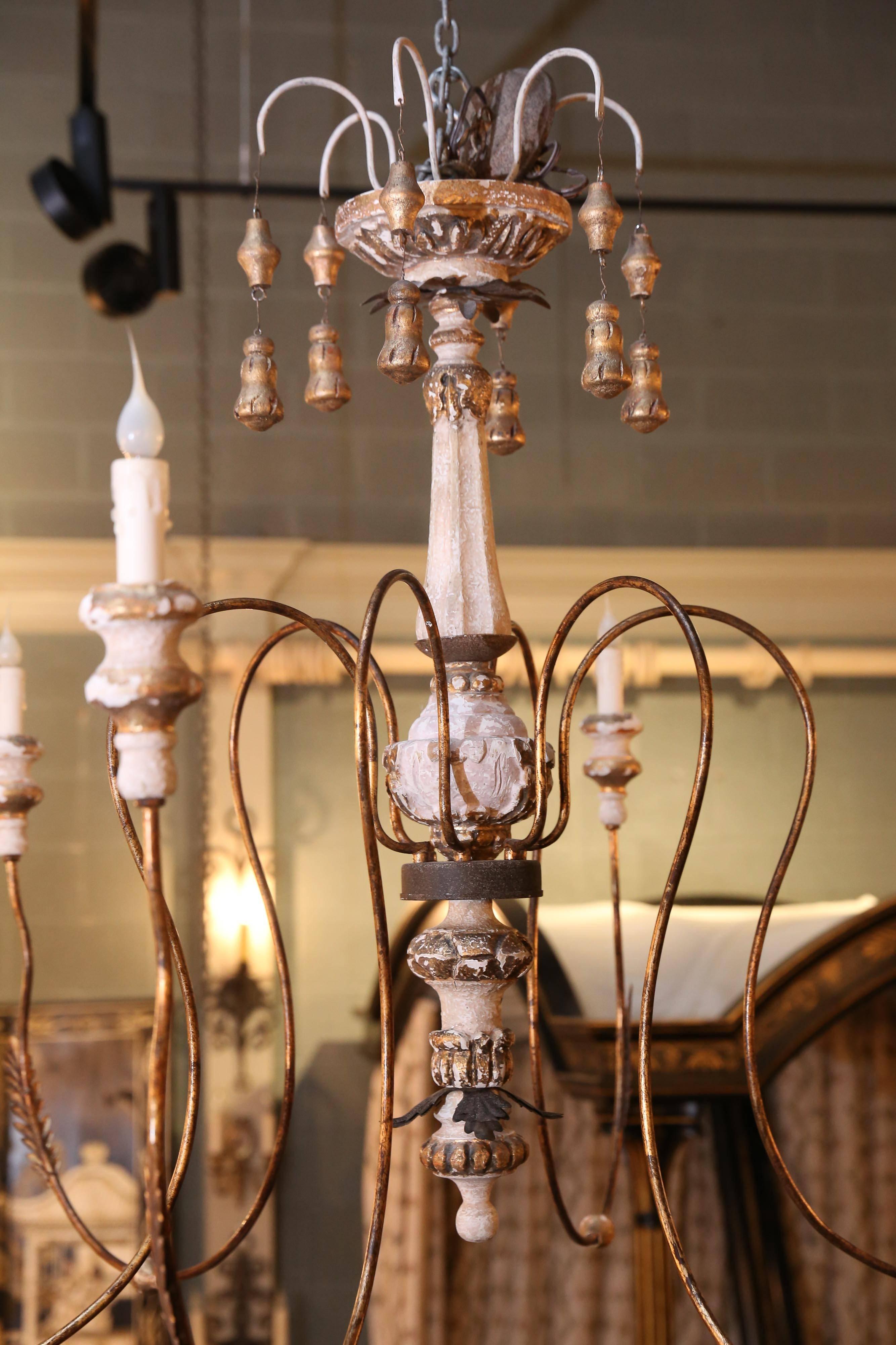 Six-light painted Swedish chandelier with turned wooden body, metal arms, and tassels.