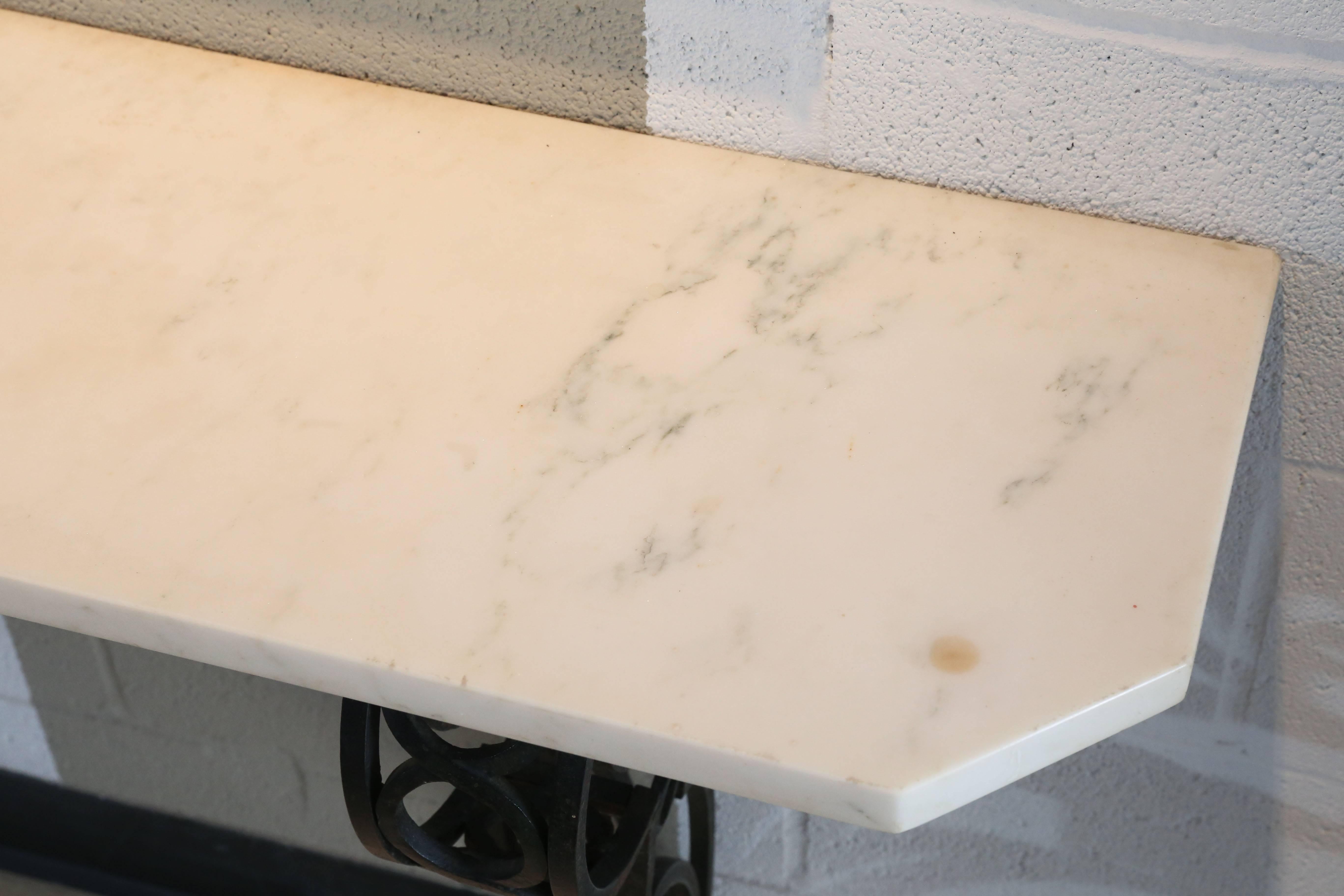 Narrow wall-mounted console is topped by a white marble top cut to shape of base.

Ideal for a small entry