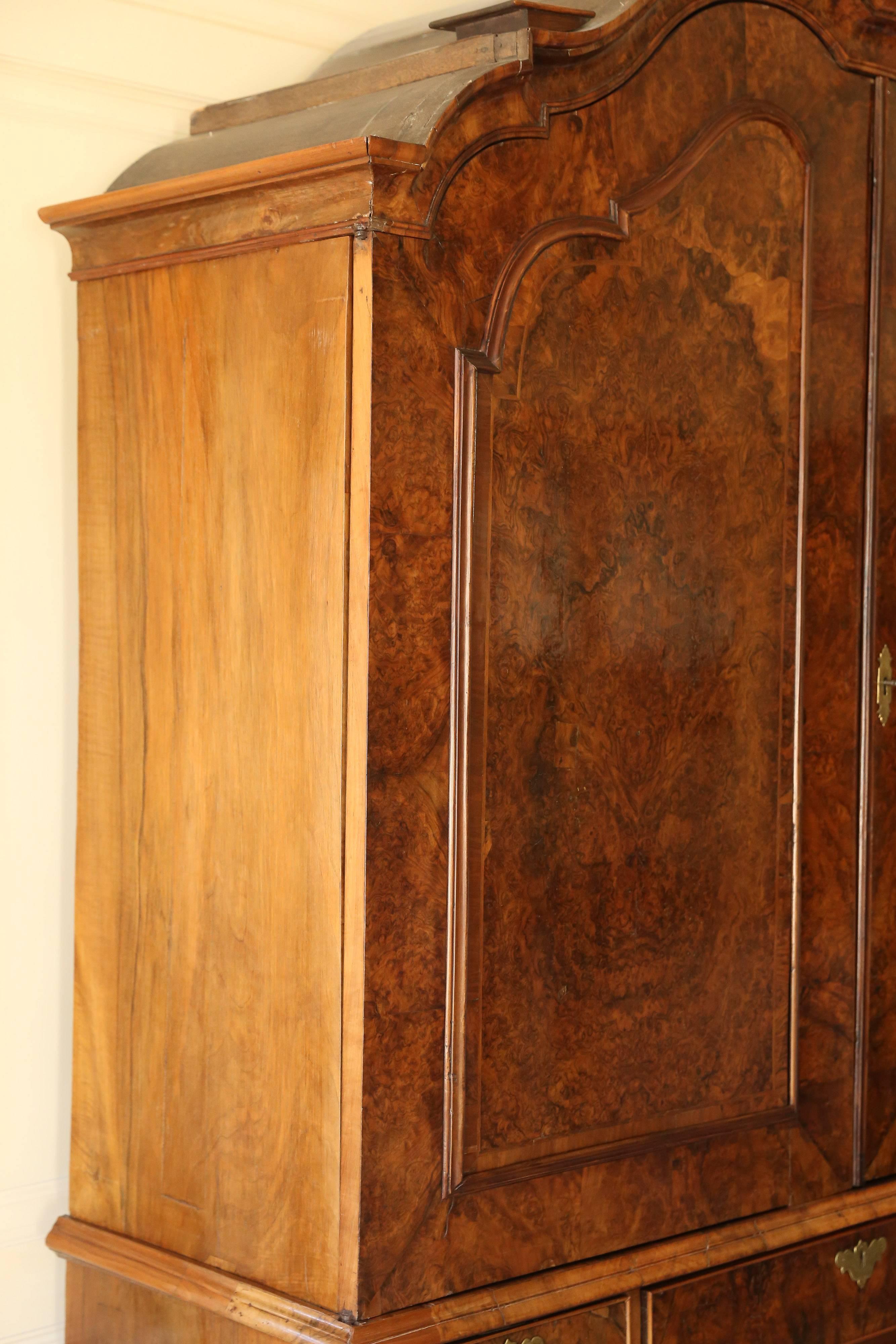 Extremely handsome linen cabinet with fully upholstered top cabinet, with two shelves  Chest base has three full width drawers under three smaller drawers.  Drawers feature a pull-out desk with. Walnut Burl has a beautiful patina.