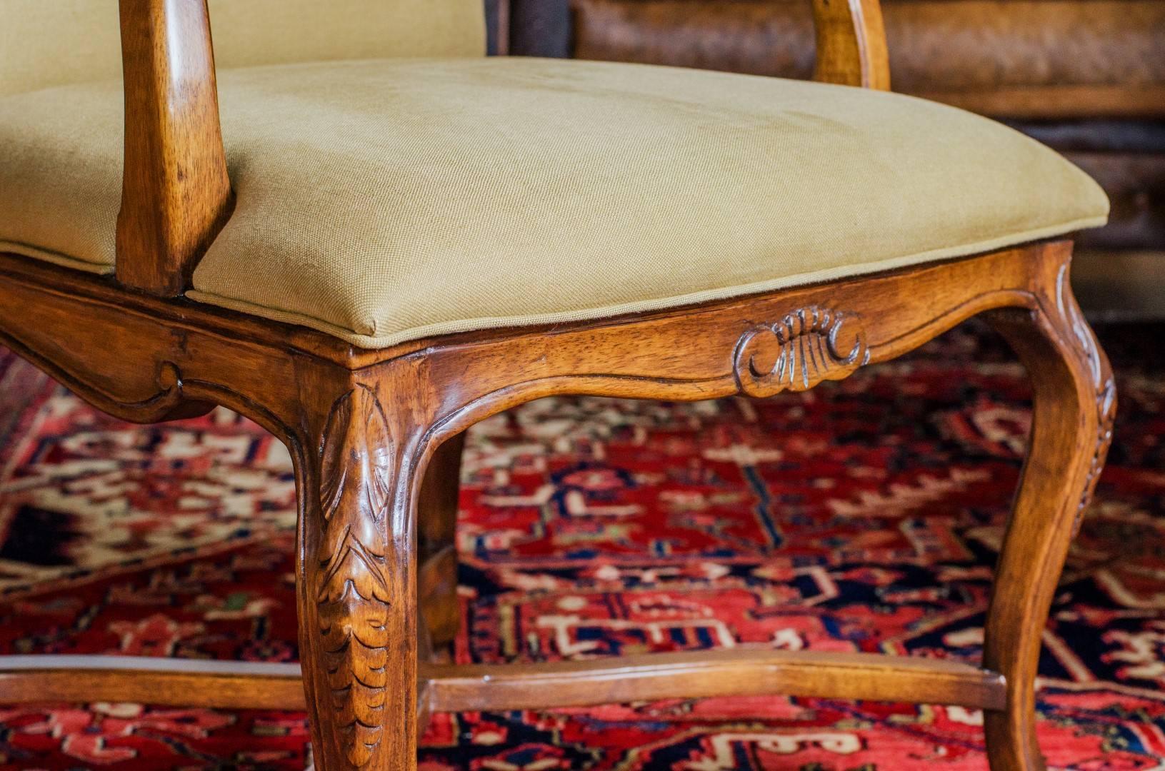 Set of two-arm and six armless chairs have
 carving on apron and legs.

Legs are connected with curved stretchers.

The back and seat are fully upholstered.

Very handsome.

Made in England.