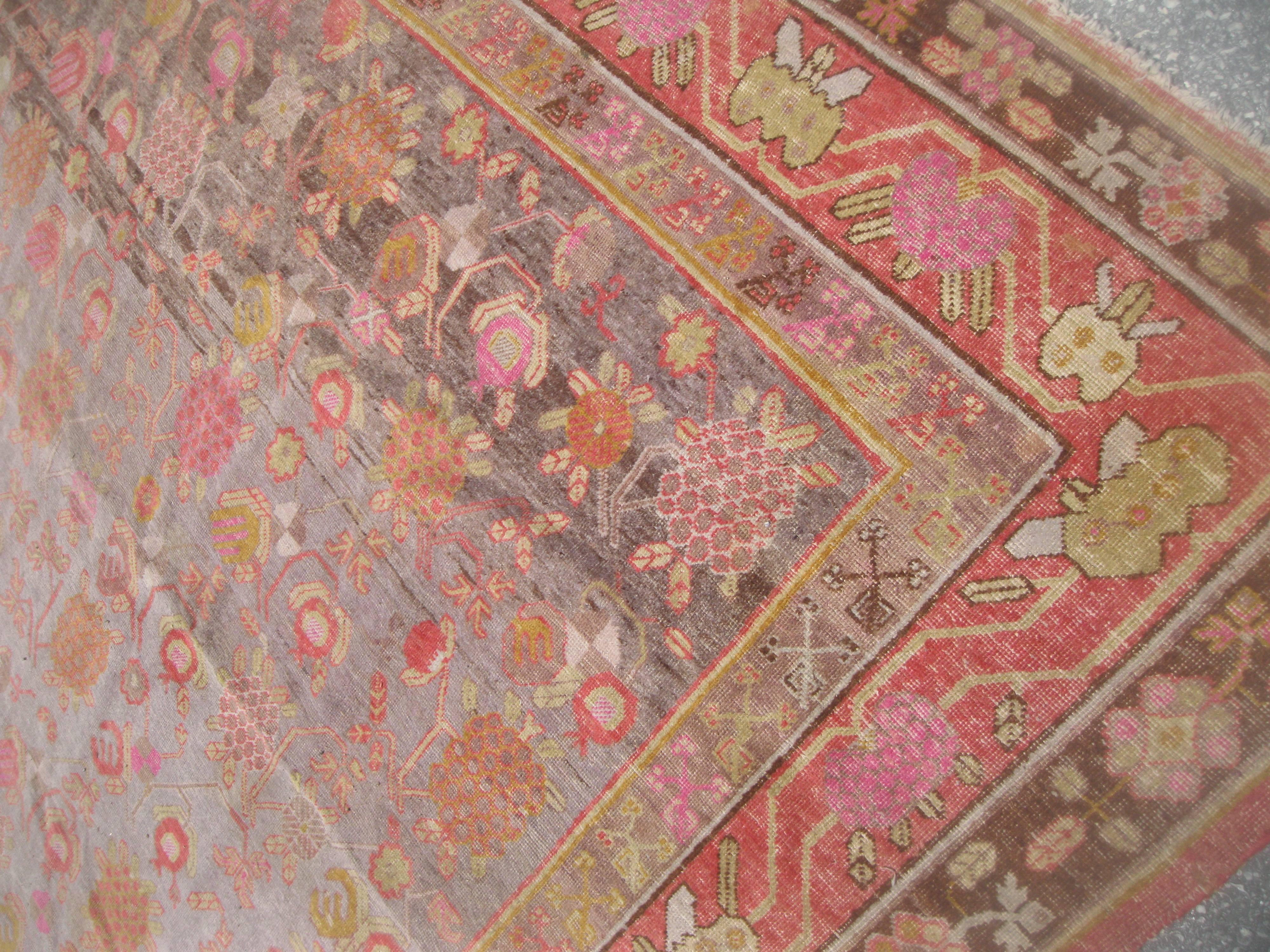20th Century Antique Khotan Rug with Eight Band Border in Browns and Oranges For Sale
