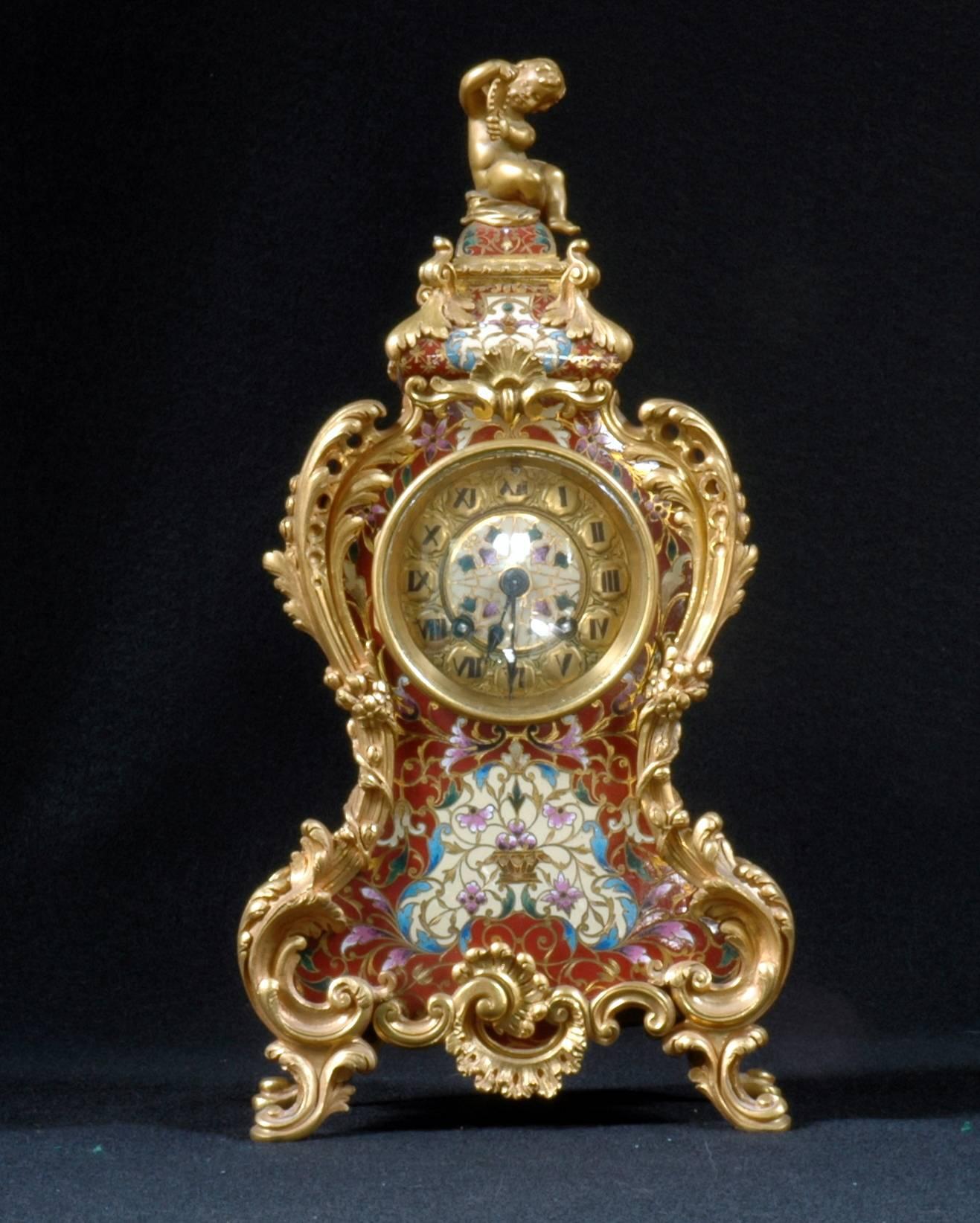 Tiffany enamel clock has a bronze ormolu framework enclosing panels of French Champleve.

A gilt putti that sits on top of dome on top.

Stamped on the backplate of the movement: Tiffany
Medaille d'Argent Vincenti & Cie 1855

Stamped into