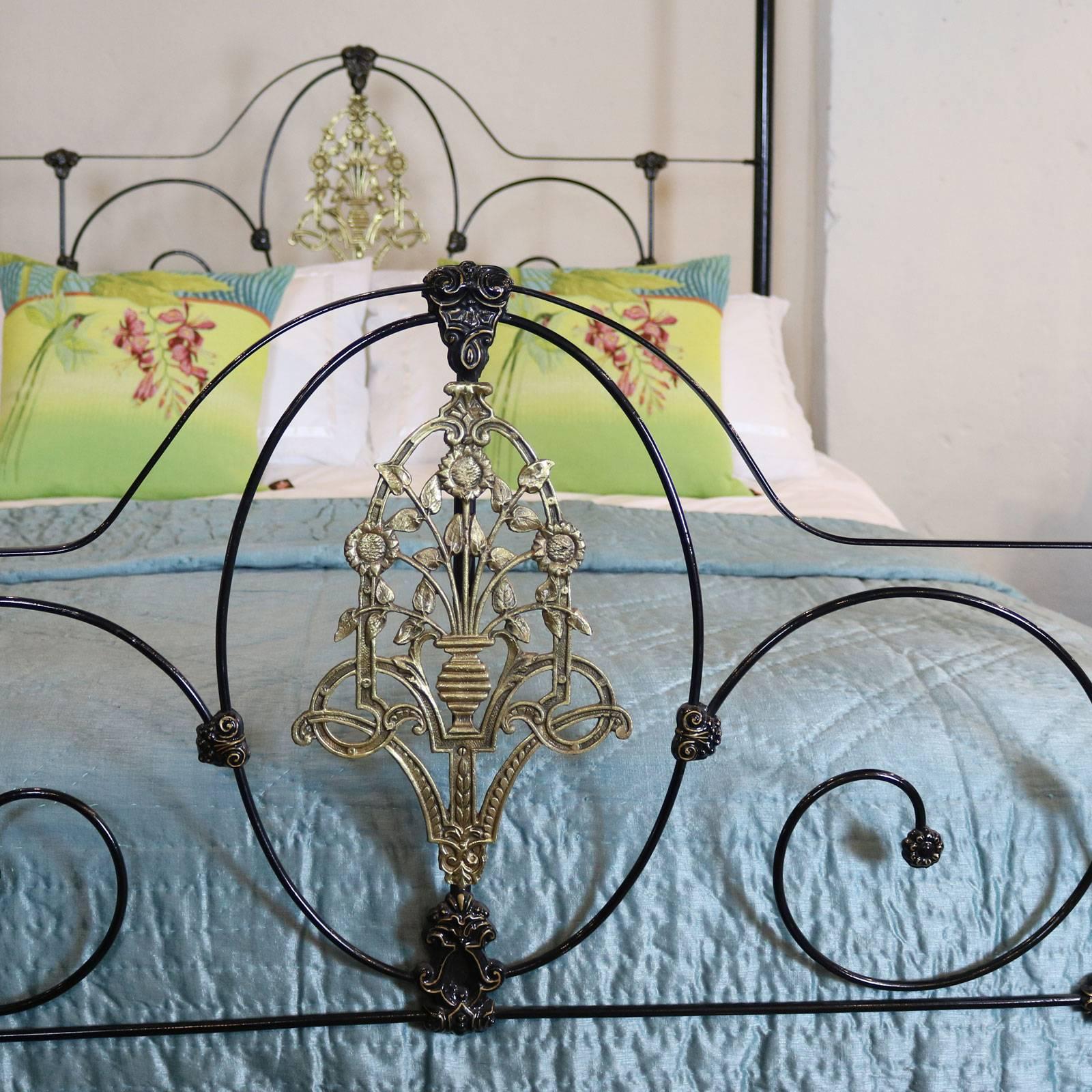 A cast iron four-poster bed bed from the mid-Victorian era restored in black with gold-lined cast iron mouldings, simple arched canopy and central brass casting depicting sunflowers.

The bed accepts a British king-size or American queen-size (60
