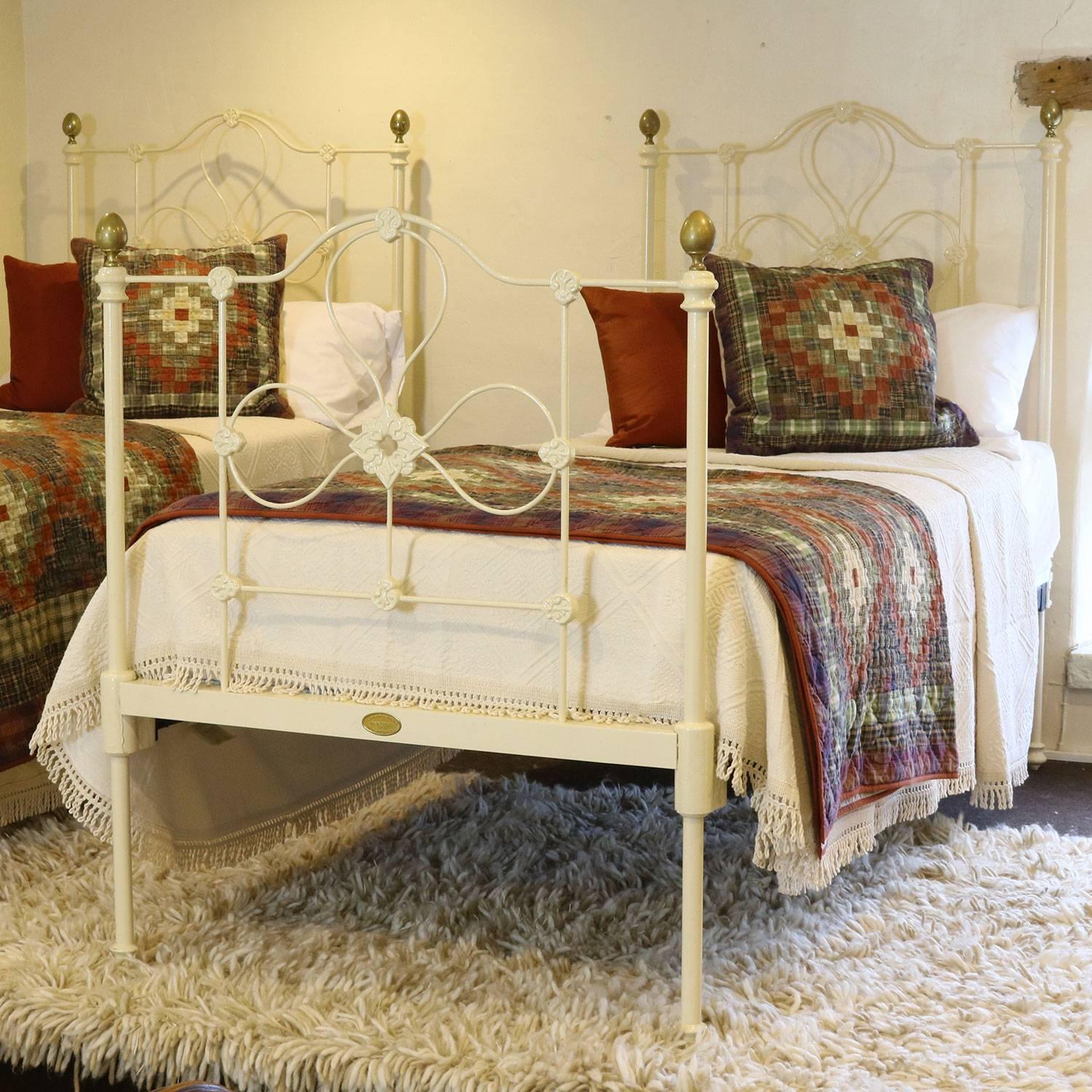 An attractive matching pair of twin single beds finished in cream with egg-shaped brass knobs and decorative castings.

These beds accept 3'0