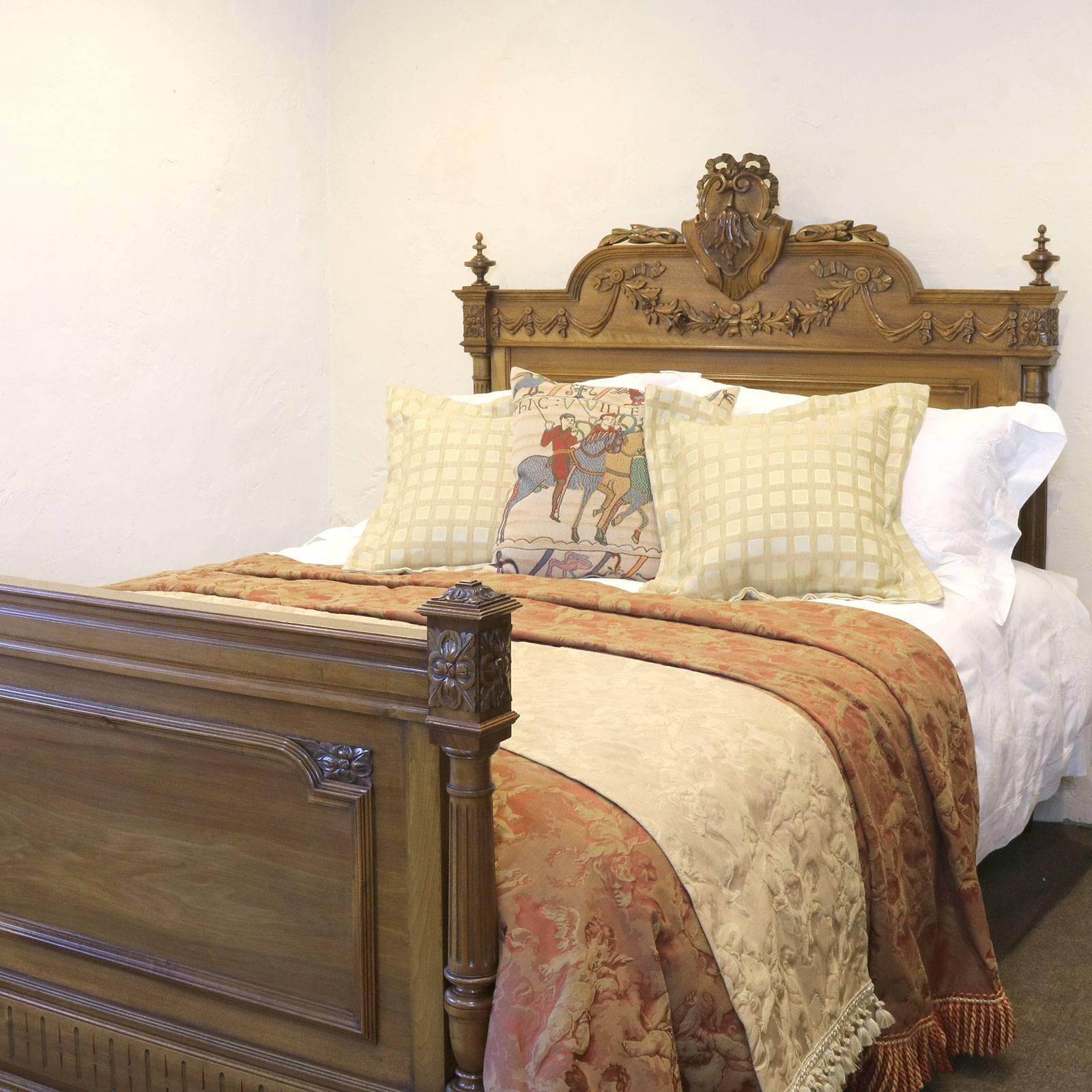 A wooden antique bed with fine carvings, turned finials and decorative pediment. 

This bed accepts a British king-size or American queen-size (60 inches, 5ft or 150cm wide) base and mattress set.

The price is for the bed frame alone. The base,