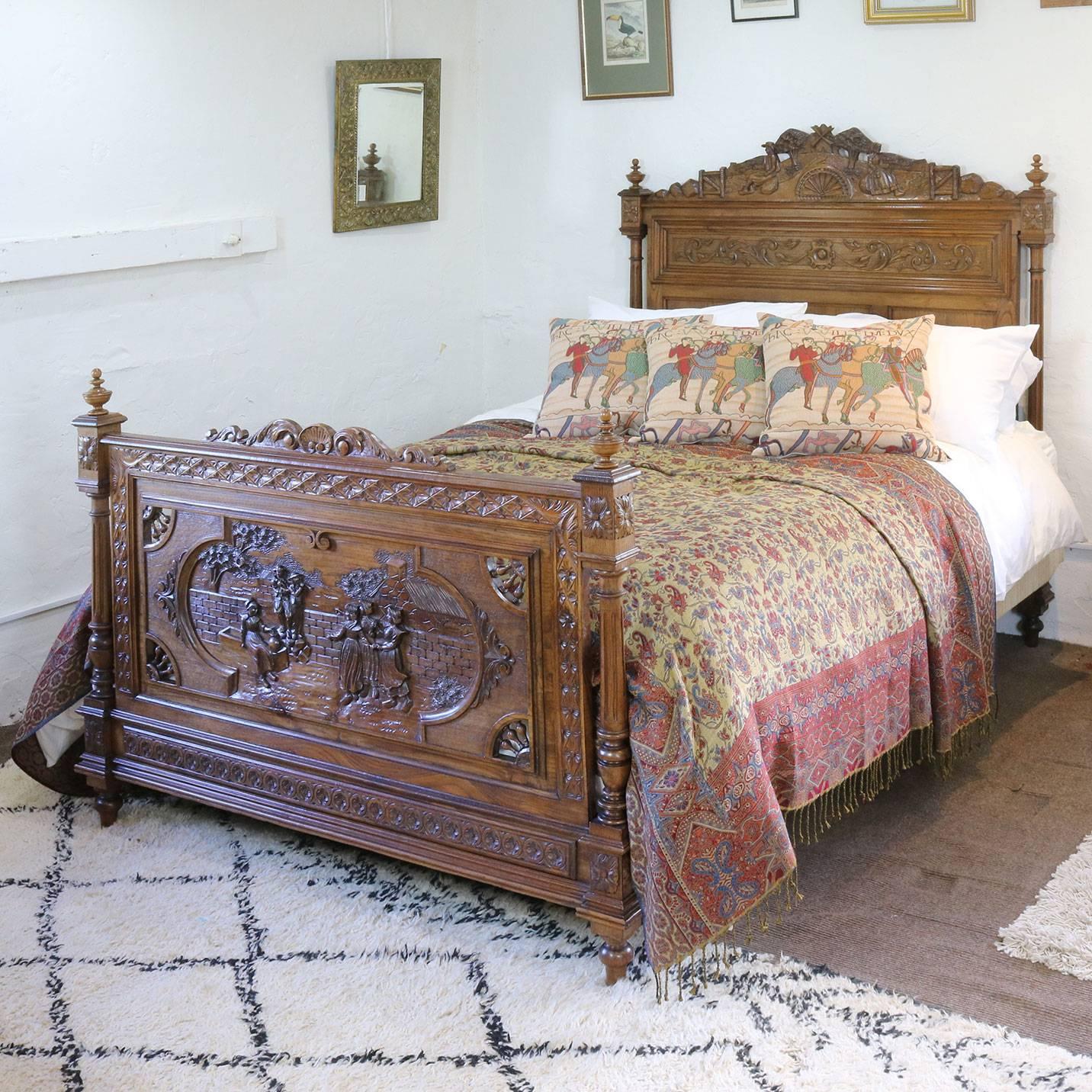 An oak bed from Brittany with ornately carved scenes depicting a dancing and revelry. 

This bed accepts a British king-size or American queen-size (60 inches, 5ft or 150 cm wide) base and mattress set.

The price is for the bed frame alone. The