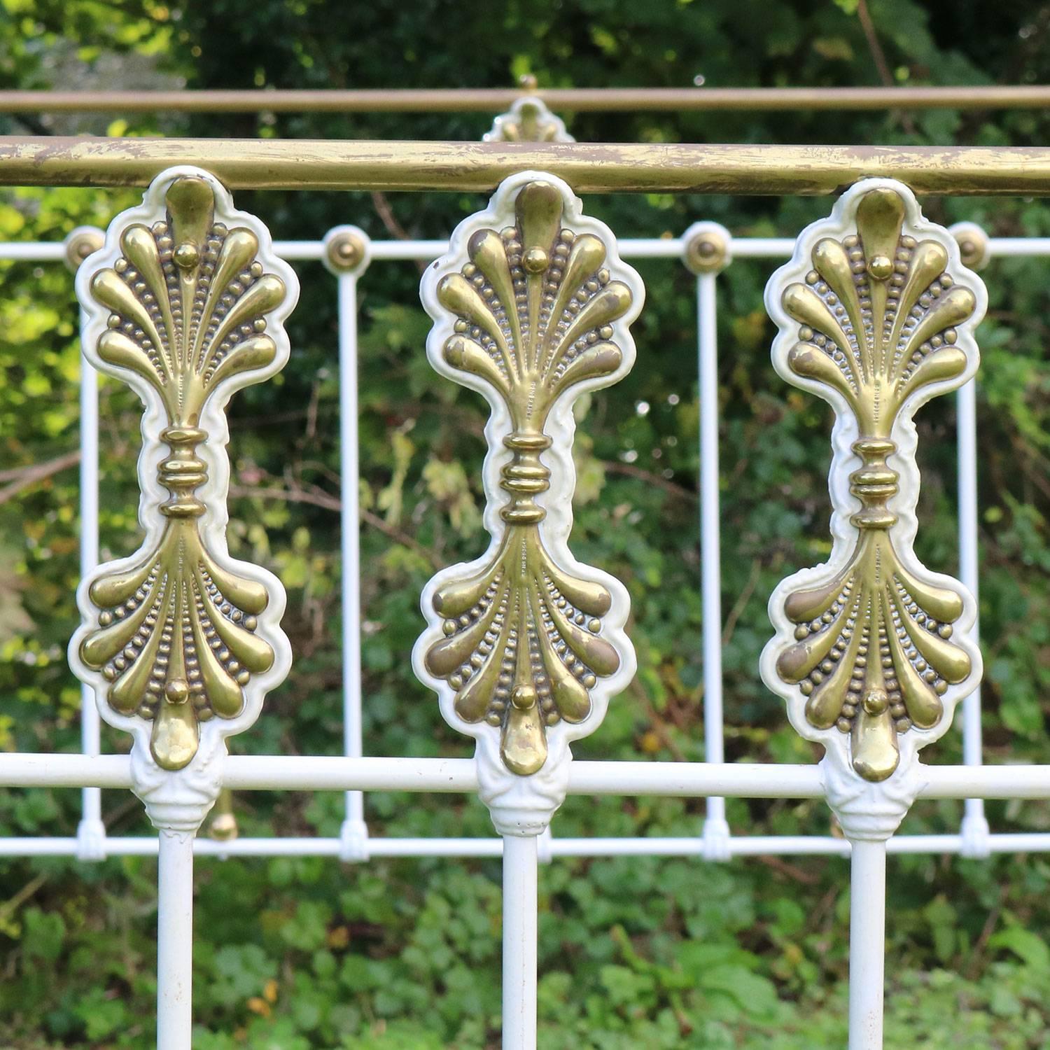 A decorative brass and iron bed with ornate panel decoration, finished in cream.

This bed accepts a British king-size or American queen-size (5ft, 60in or 150cm wide) base and mattress set.

The price includes a standard firm bed base to support