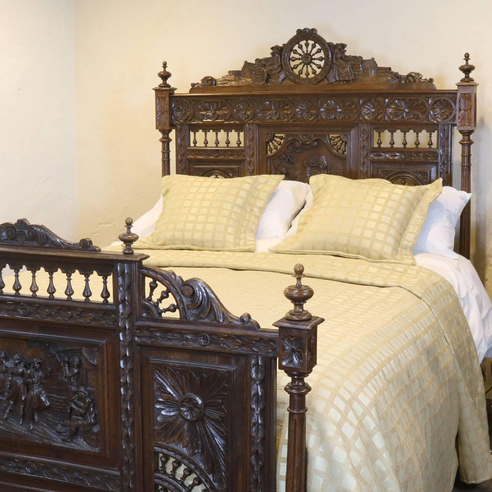 A superb Breton oak bed with decoratively carved panels depicting rural scenes of revelry and 'ship's wheel' spindles relating to the sea, circa 1900.

This bed accepts a 60in wide (British King or American Queen) bed base and mattress set.

The