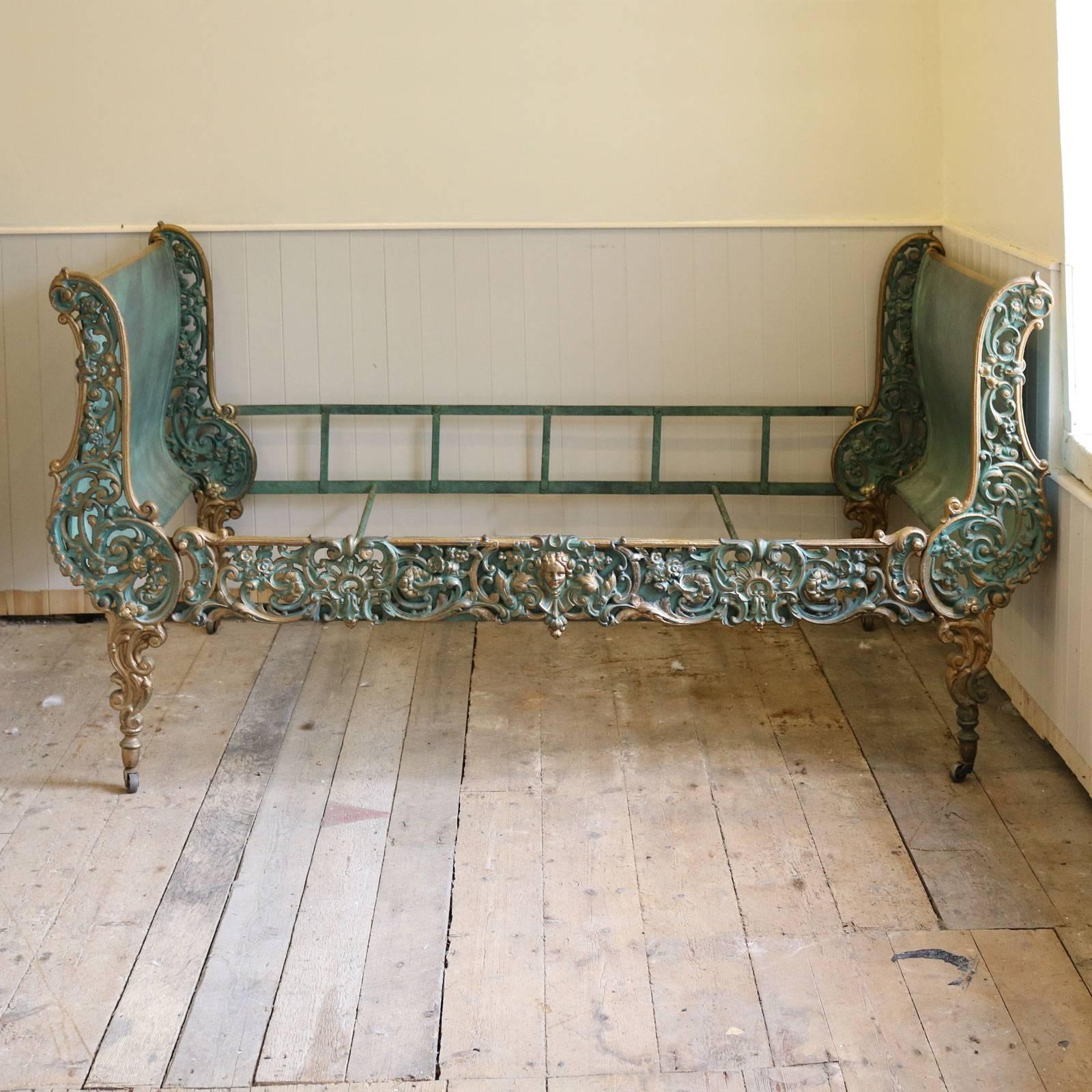 A superb example of a cast iron daybed in the Rococo style with ornate cast sides and front panel and finished in a green Verdigris with gold highlights. 

This versatile piece of furniture can be used as an occasional bed, or a sofa in a sitting