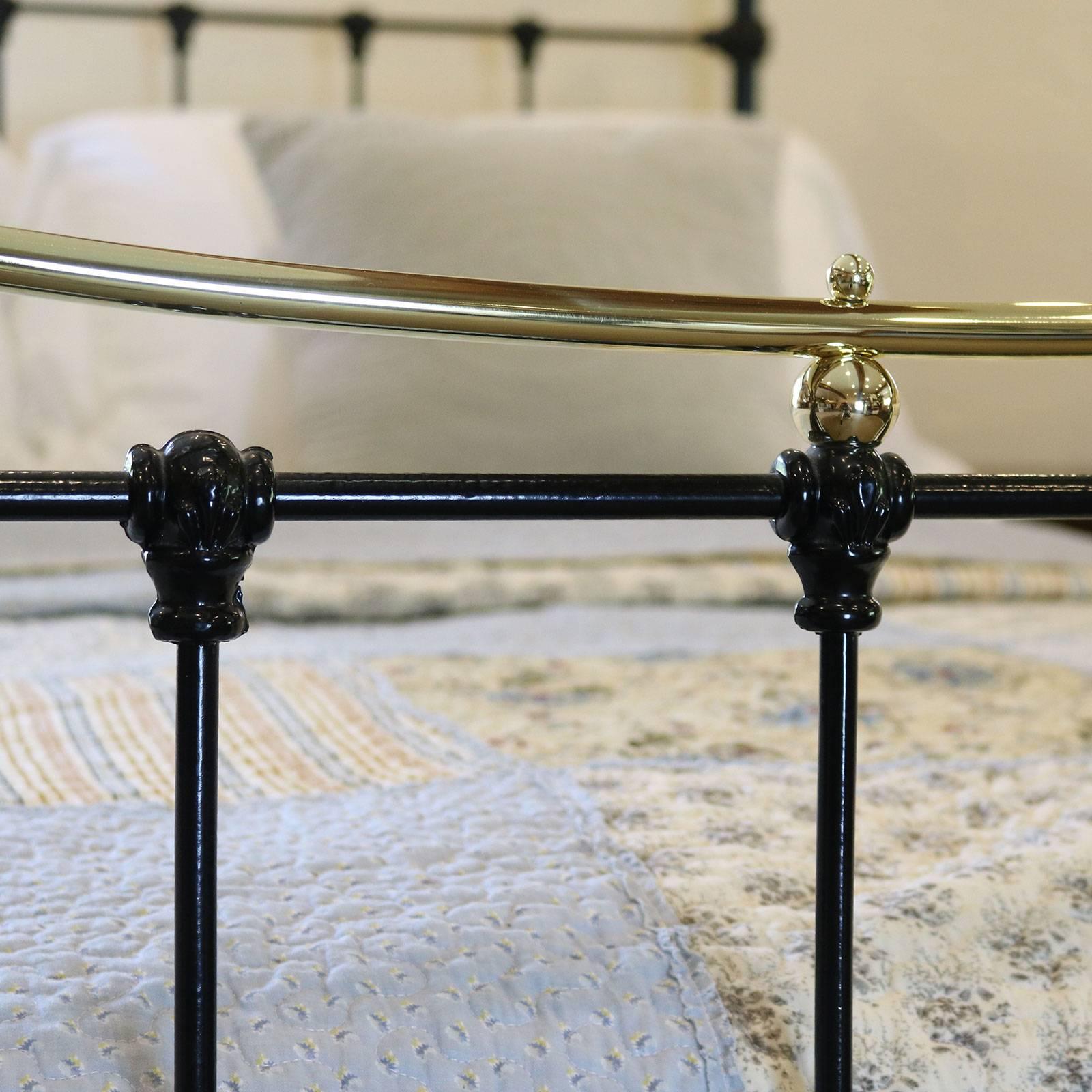 Brass and iron bed finished in black with curved brass top rails and decorative castings. This bed is totally restored and adapted from an original antique frame.

This bed accepts a British king-size or American queen-size (60 inches, 5ft or
