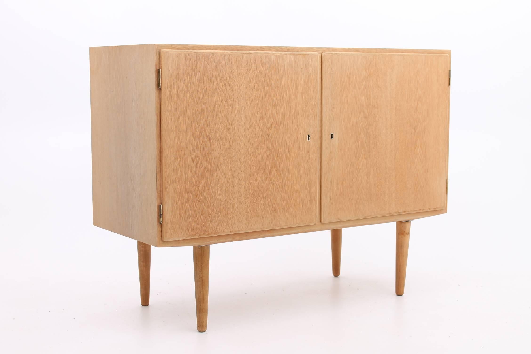 Oak cabinet designed by Poul Hundevad dating 1965. This cabinet features two locking doors with fully adjustable shelves and drawers. All of the marking and stamps are in tact and is in excellent vintage condition.