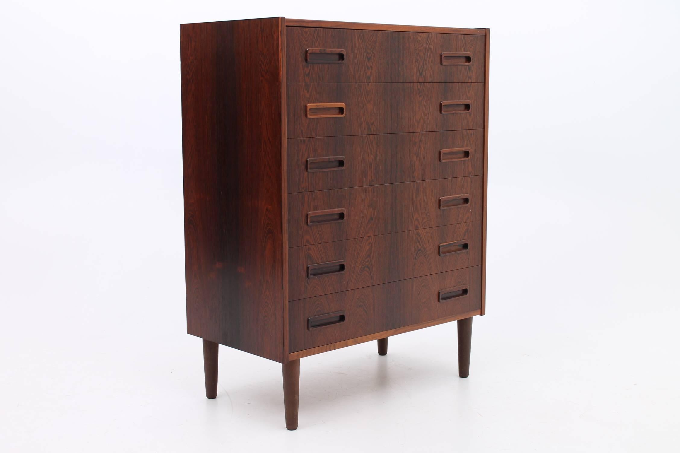 Beautiful, tall chest of drawers designed by Borge Seindal for Westergaards Møbelfabrik. This gorgeous espresso colored rosewood chest of drawers features six roomy drawers and handmade wooden handles. The wood on the chest is in exceptional