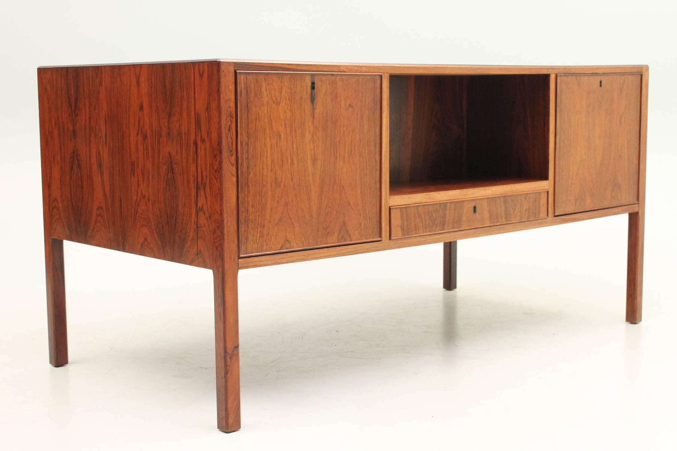 Rosewood desk designed by Arne Vodder for Helge Sibast, circa 1955. This desk has three storage drawers on either side of the seating area and three locking cabinets on the other side with a shelf in the middle for books, awards or added flair. The