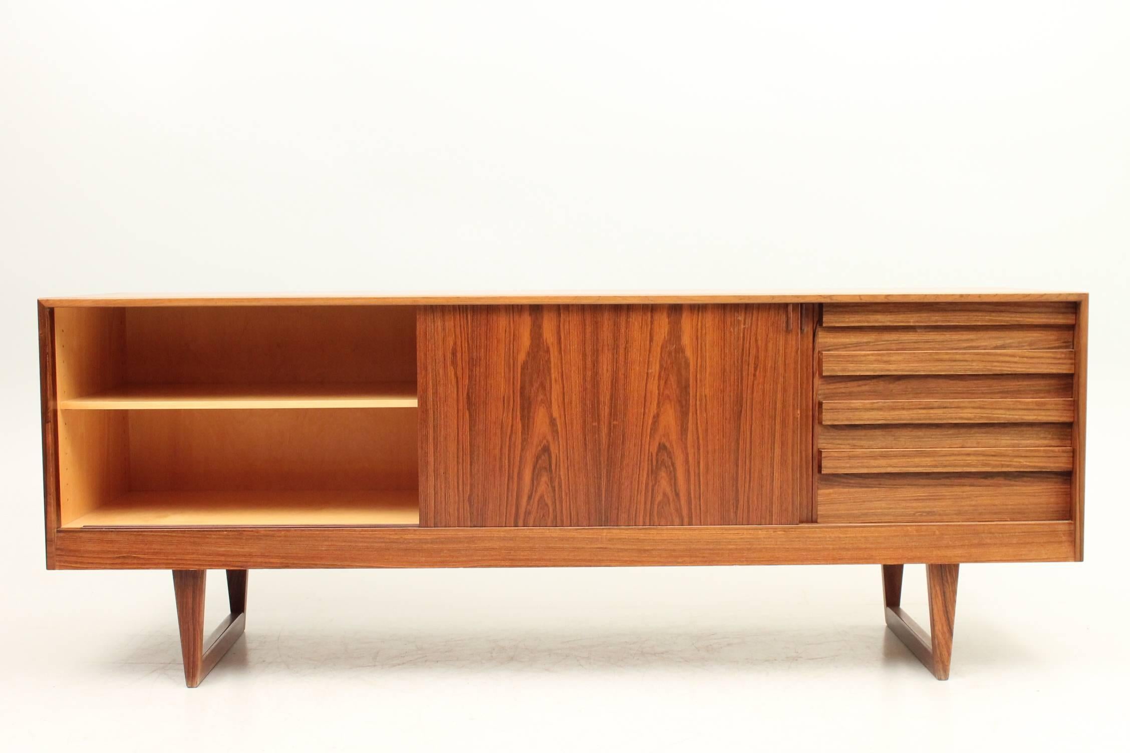 Rosewood credenza designed by Kurt Østervig for KP Møbler. The credenza has two sliding doors with fully adjustable shelves on the inside and drawers on the left hand side. There are many details on this credenza that make is super special - from