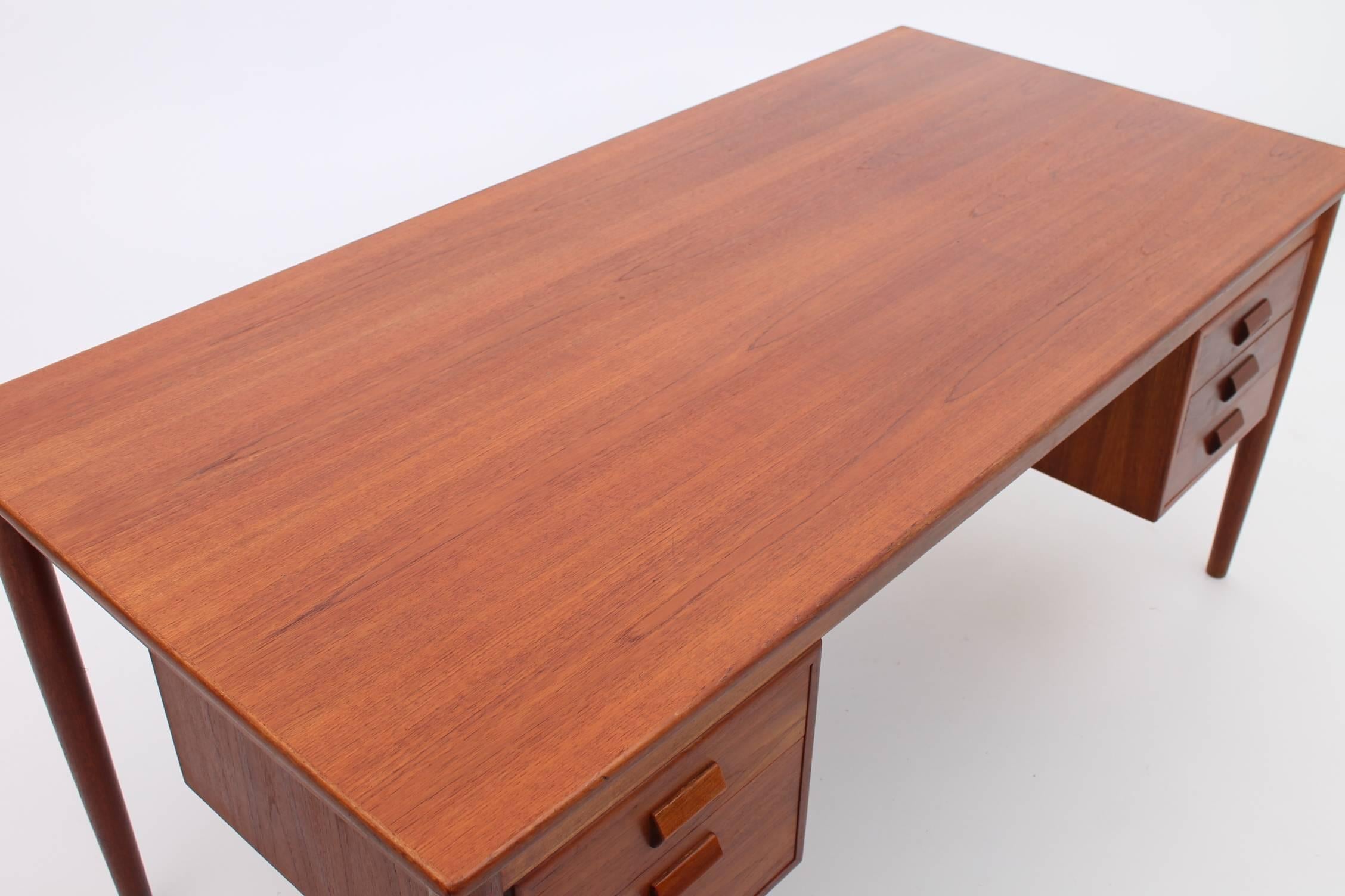 Beautiful teak desk designed by Børge Mogensen for Soborg Møbelfabrik. The desk has two floating drawers and is finished on all sides, so it looks beautiful from any angle. The desk is in excellent vintage condition with visible signs of use and