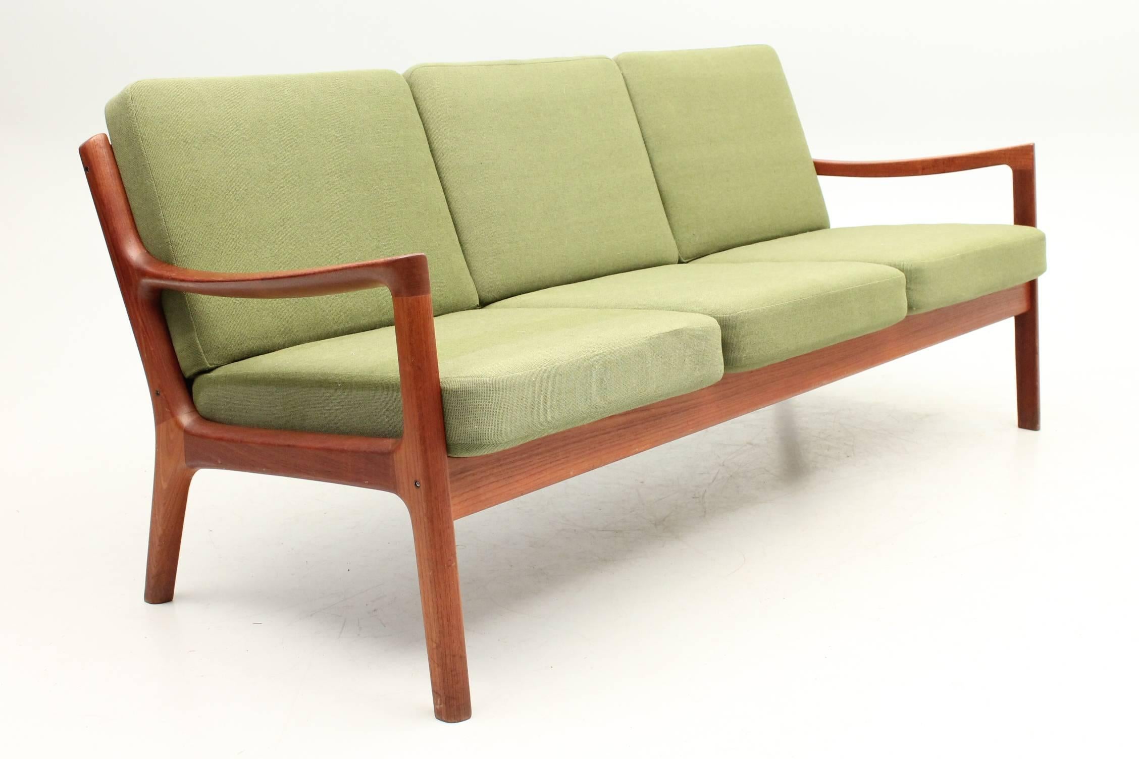 Gorgeous three-seat sofa and matching chair designed by Ole Wanscher for France and Son. The cushions are made out of green fabric that sit perfectly in the teak frame. This set is in excellent condition with very little signs of wear or use.