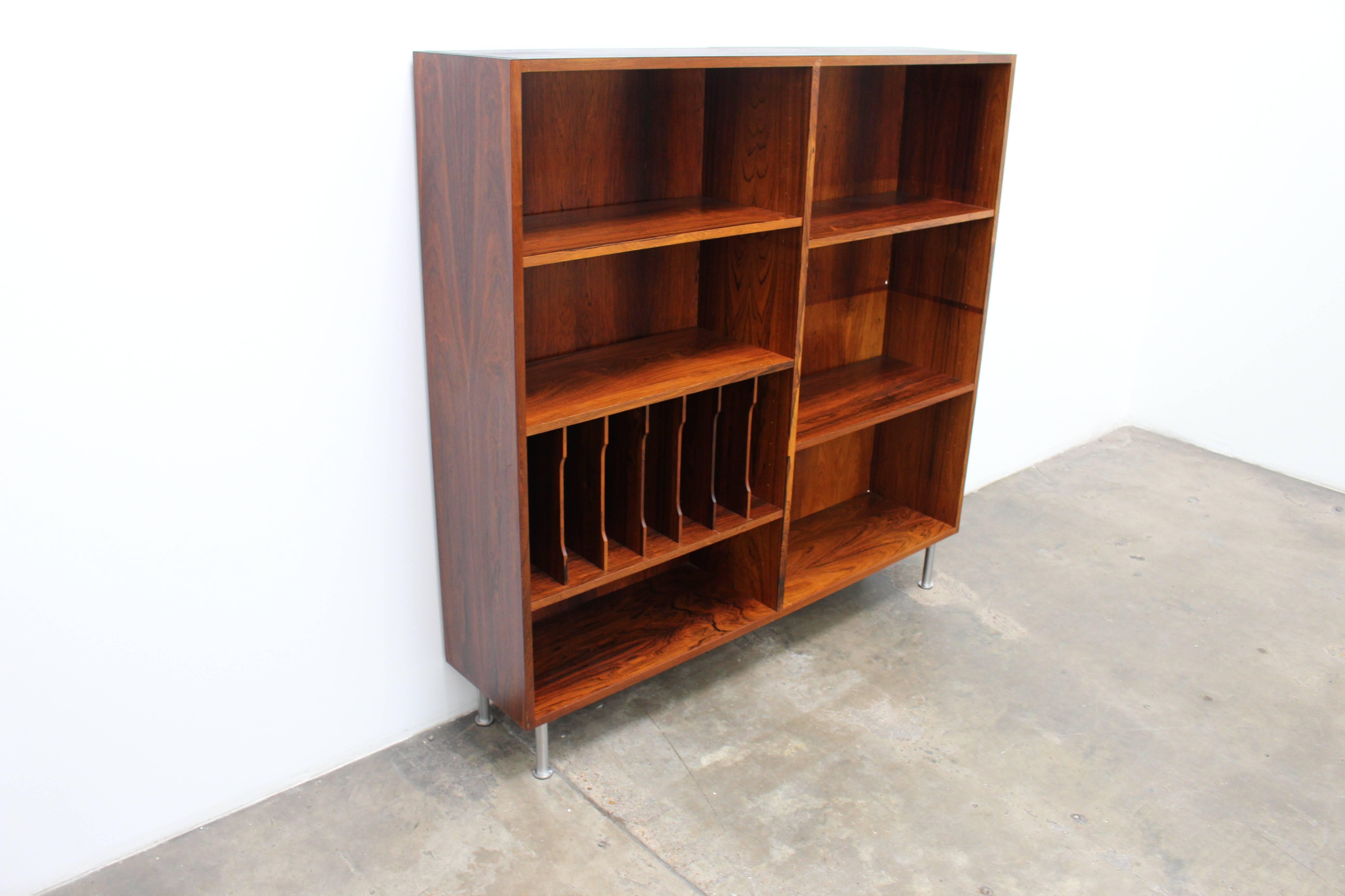 Gorgeous bookcase made of rosewood with metal legs. This bookshelf has fully adjustable shelves and is very versatile to fit your storage needs and personalize as you wish. The bookcase is in excellent shape with very minor fading for its age and is
