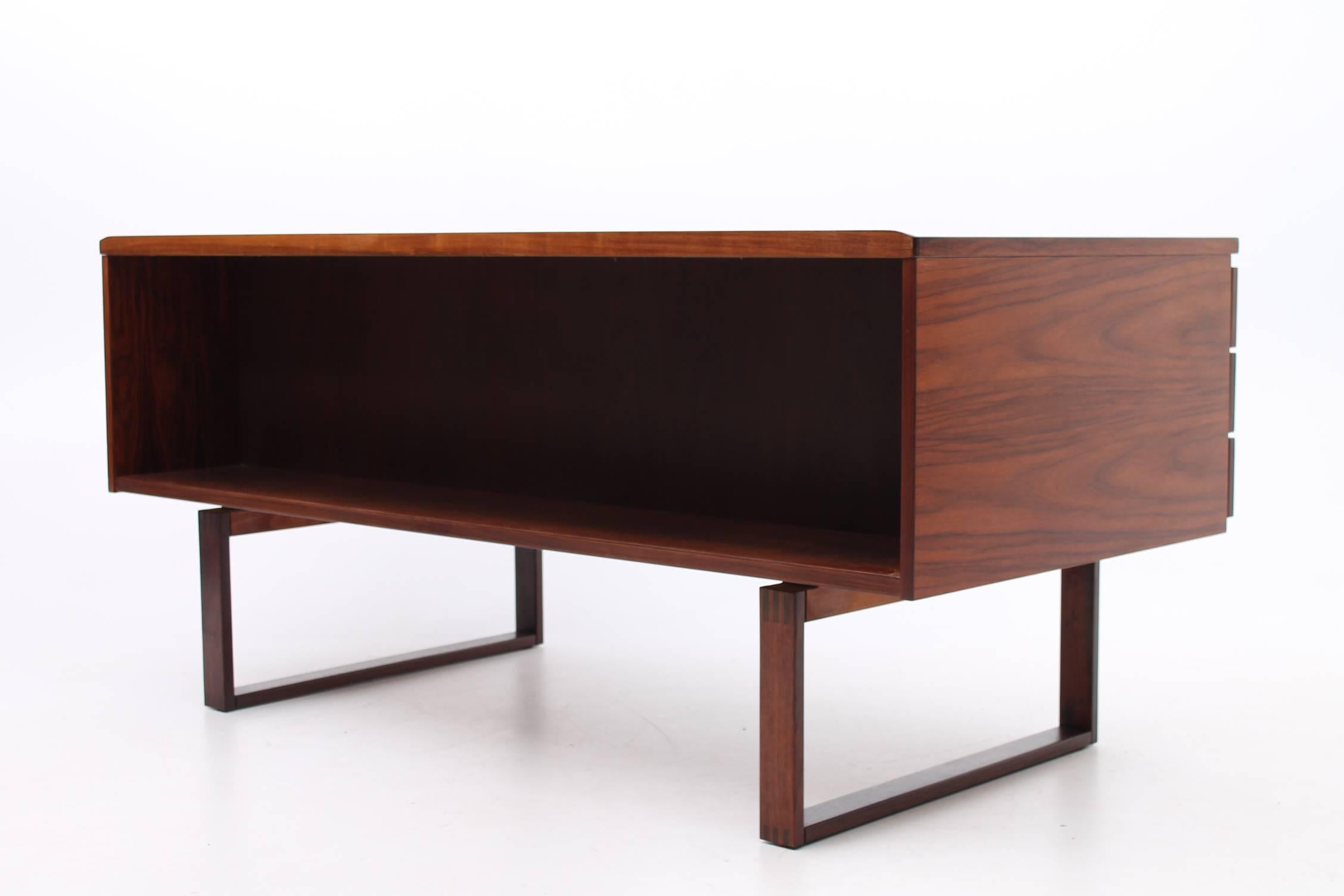 Gorgeous desk made out of rosewood and designed by Preben Schou Andersen for PSA Furniture. This desk features three drawers on either side of the opening as well as a large open shelf on the backside to display books, awards and personal