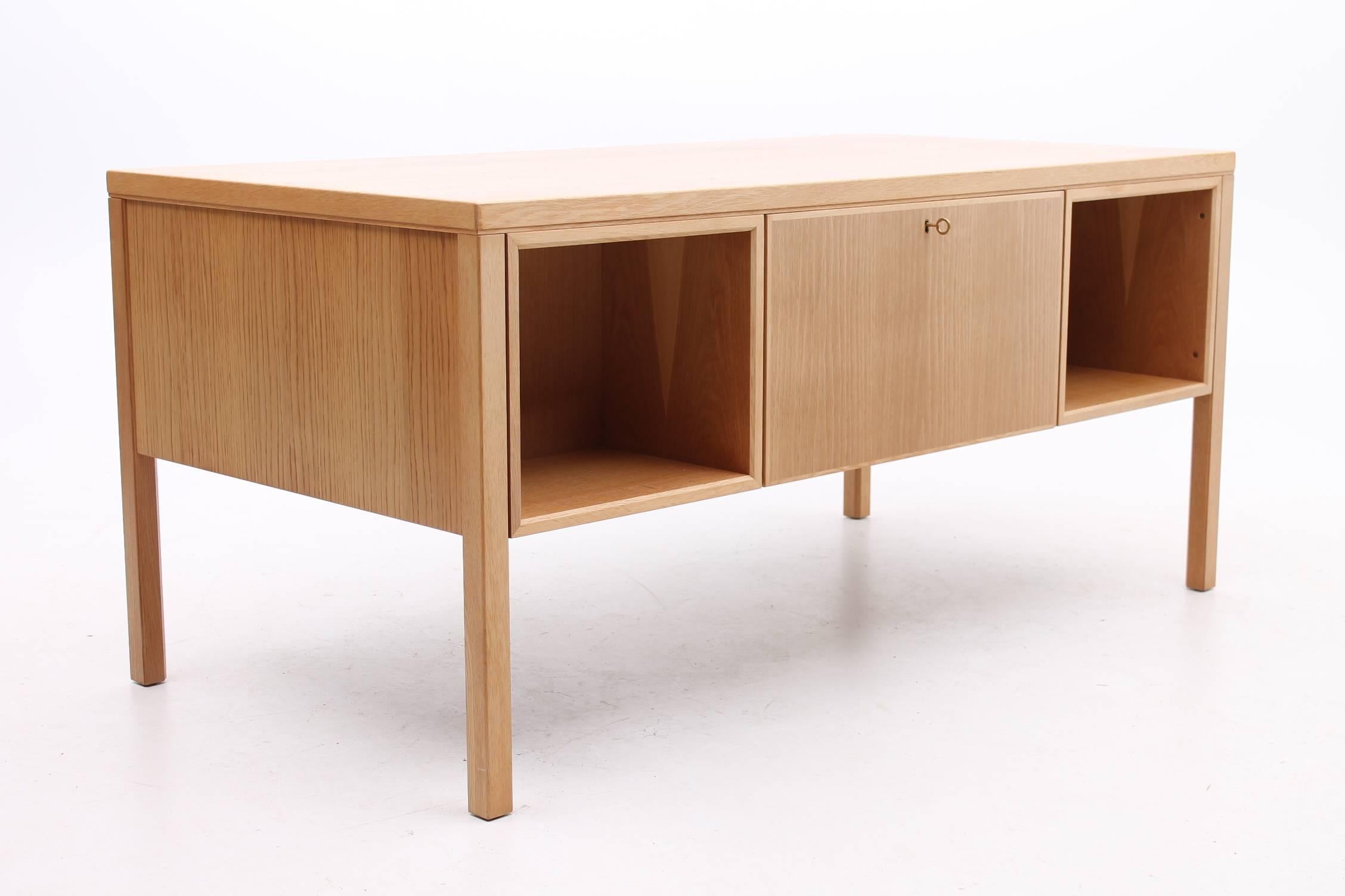 Oak desk designed by Gunni Omann for Omann Jun Møbelfabrik. The oak on the desk is a light straw color and is in excellent condition. The desk features three drawers on either side of the chair opening and the top two drawers on either side lock.