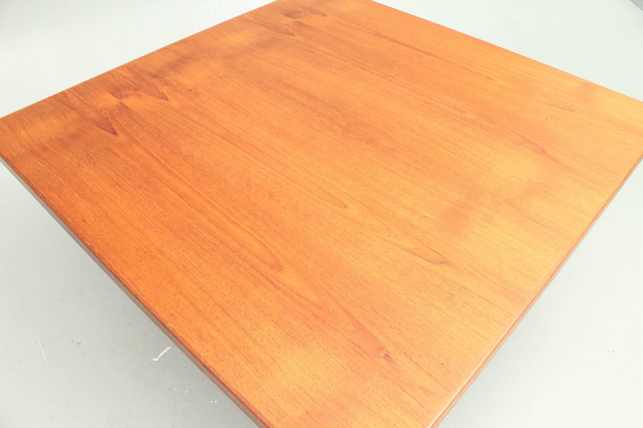 Beautiful Finn Juhl FJ57 coffee table manufactured by Niels Vodder. This table features a square teak top mounted on an anodized steel frame with teak shoes at the bottom of the base. The table is in excellent condition and the tabletop has been