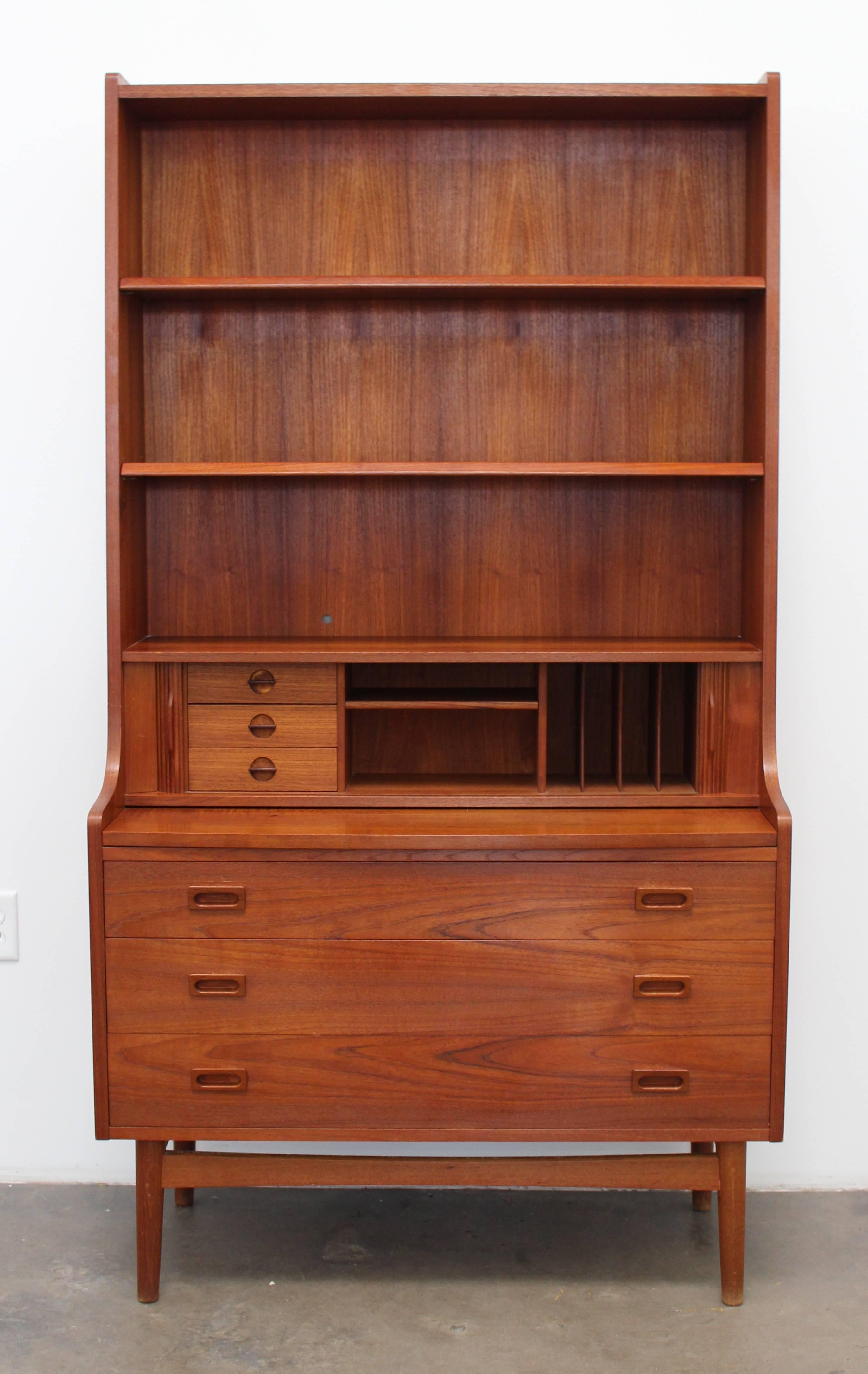 Tall bookcase or secretary unit designed by Johannes Sorth for Nexø Møbelfabrik made of teak. This item is extremely versatile and can work in a bedroom, home office, traditional office or living room. The upper portion of the shelf contains 3