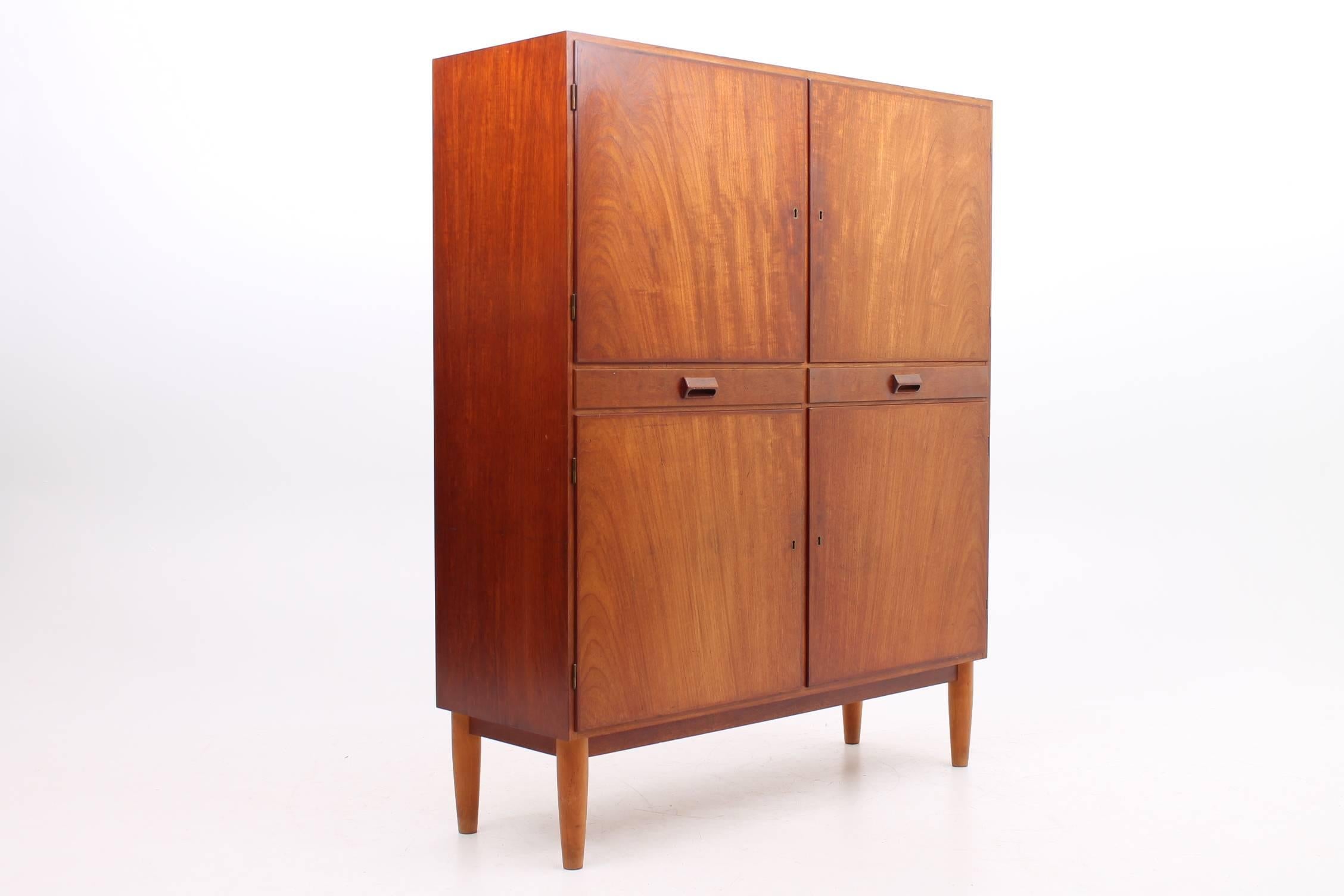 Beautiful cabinet designed by Børge Mogensen made of solid teak. This cabinet features four locking sections with adjustable shelves separated by two slim drawers. This cabinet is very versatile and would work great in any room of the house -