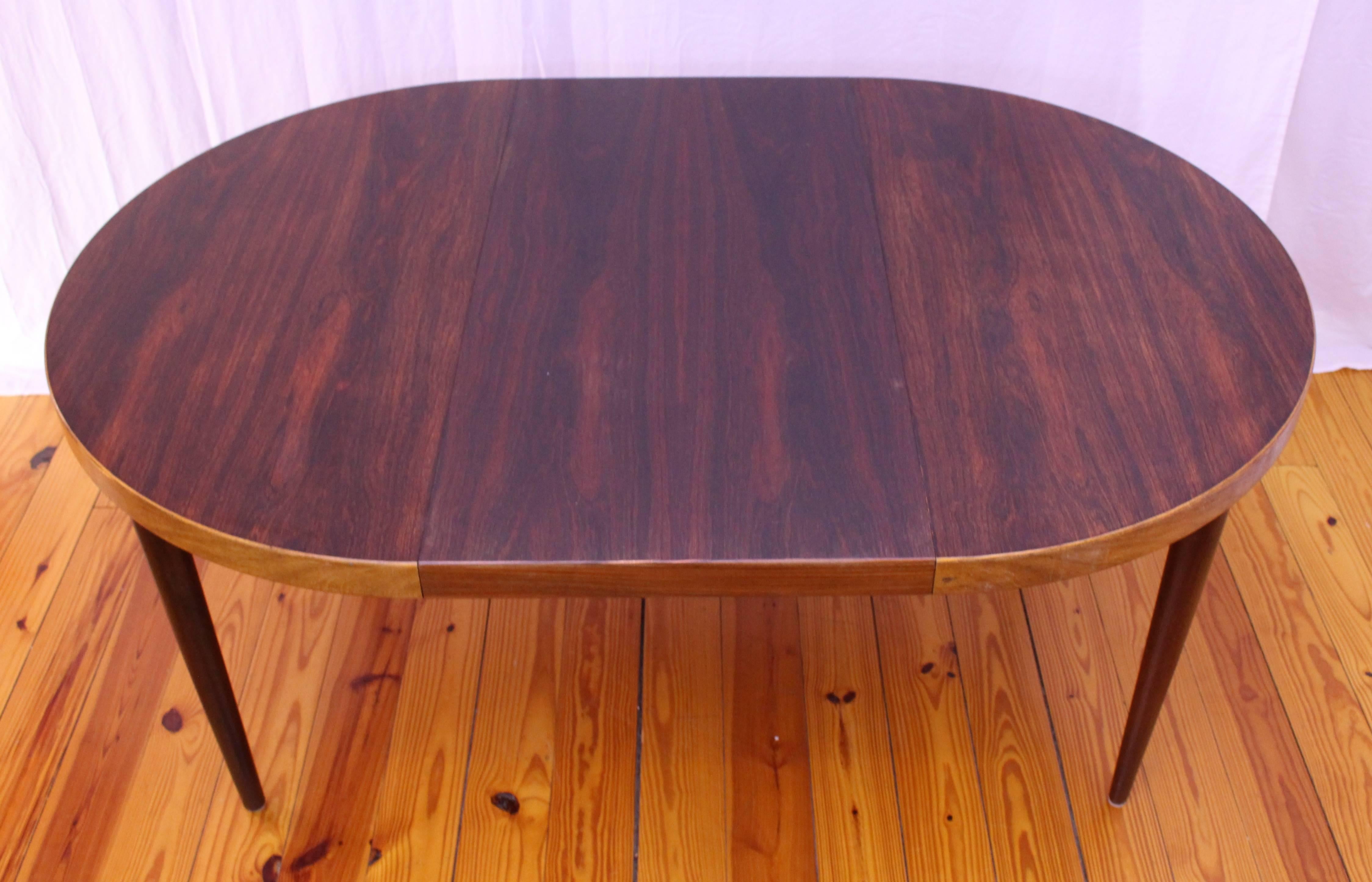 Unique and beautiful dining table designed by Kai Kristiansen. The table is made out of rosewood with a teak band around the edge encompassing the rosewood table. The teak band is lighter than the top and legs of the table and is absolutely