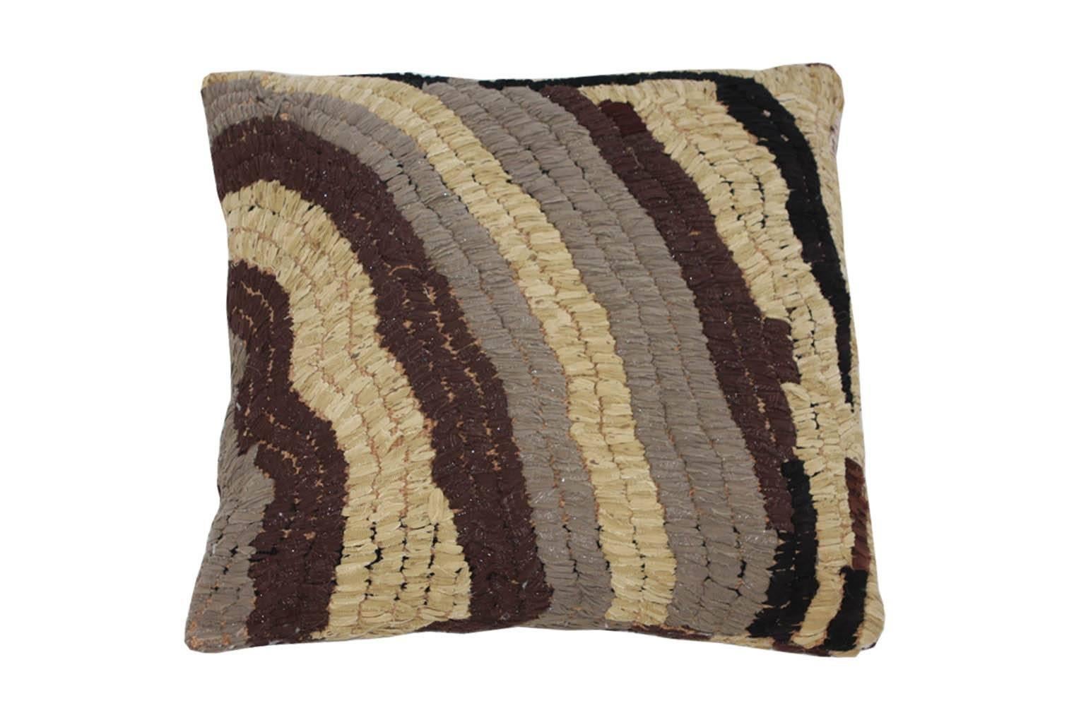 Floor pillow made with vintage Moroccan textile rug. 
This pillow is tan, grey, and dark brown with accent of metallic silver. 
Measures: 28" L x 27" W.