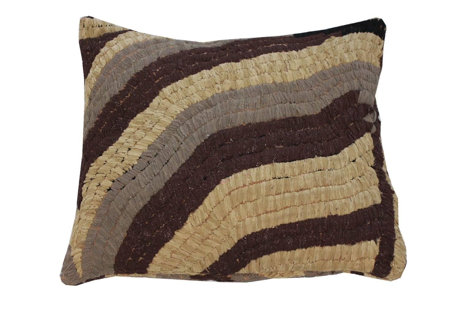 Floor pillow made with vintage Moroccan textile rug. 
This pillow is tan, taupe, and brown with metallic silver.
Measures: 28" L x 27" W.