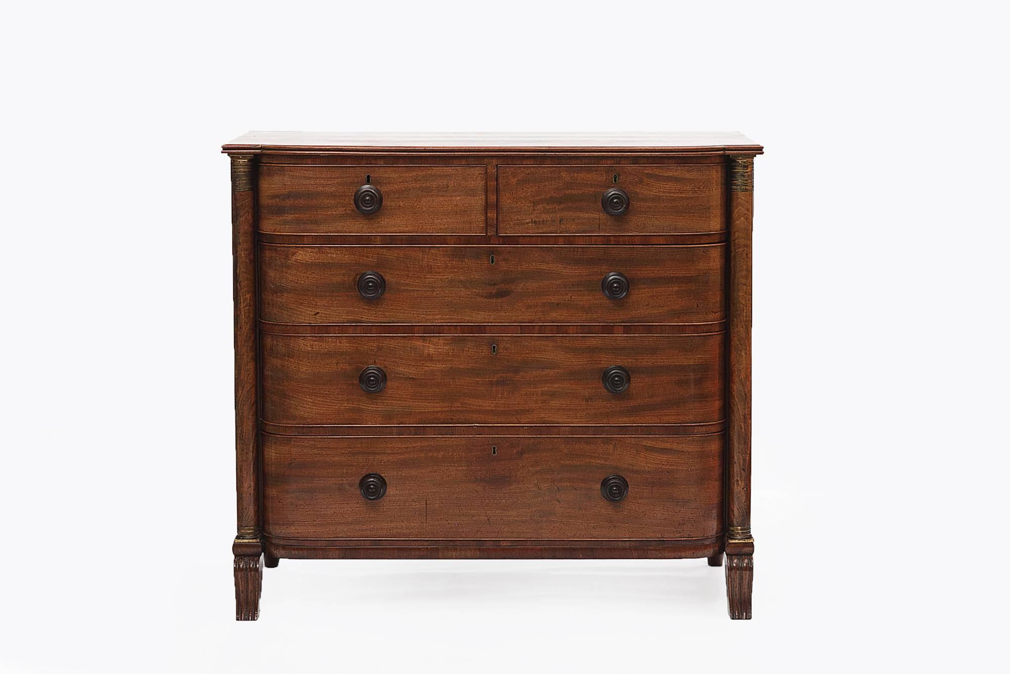 19th Century mahogany bow front chest of drawers, two short drawers over four long graduated drawers with ebonised knobs flanked by engaged columns with brass capitols.