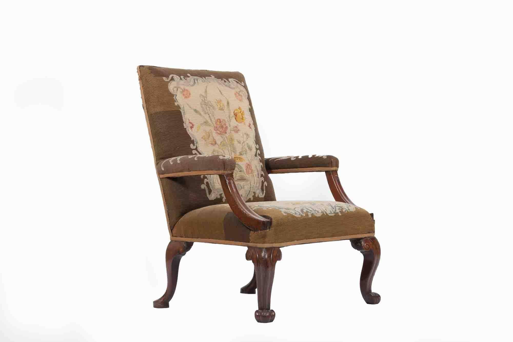 19th century Gainsborough armchair, The square padded back above straight padded arms with unusual incised downswept supports. All upholstered in petit point raised on incised scroll carved cabriole legs and scroll feet.