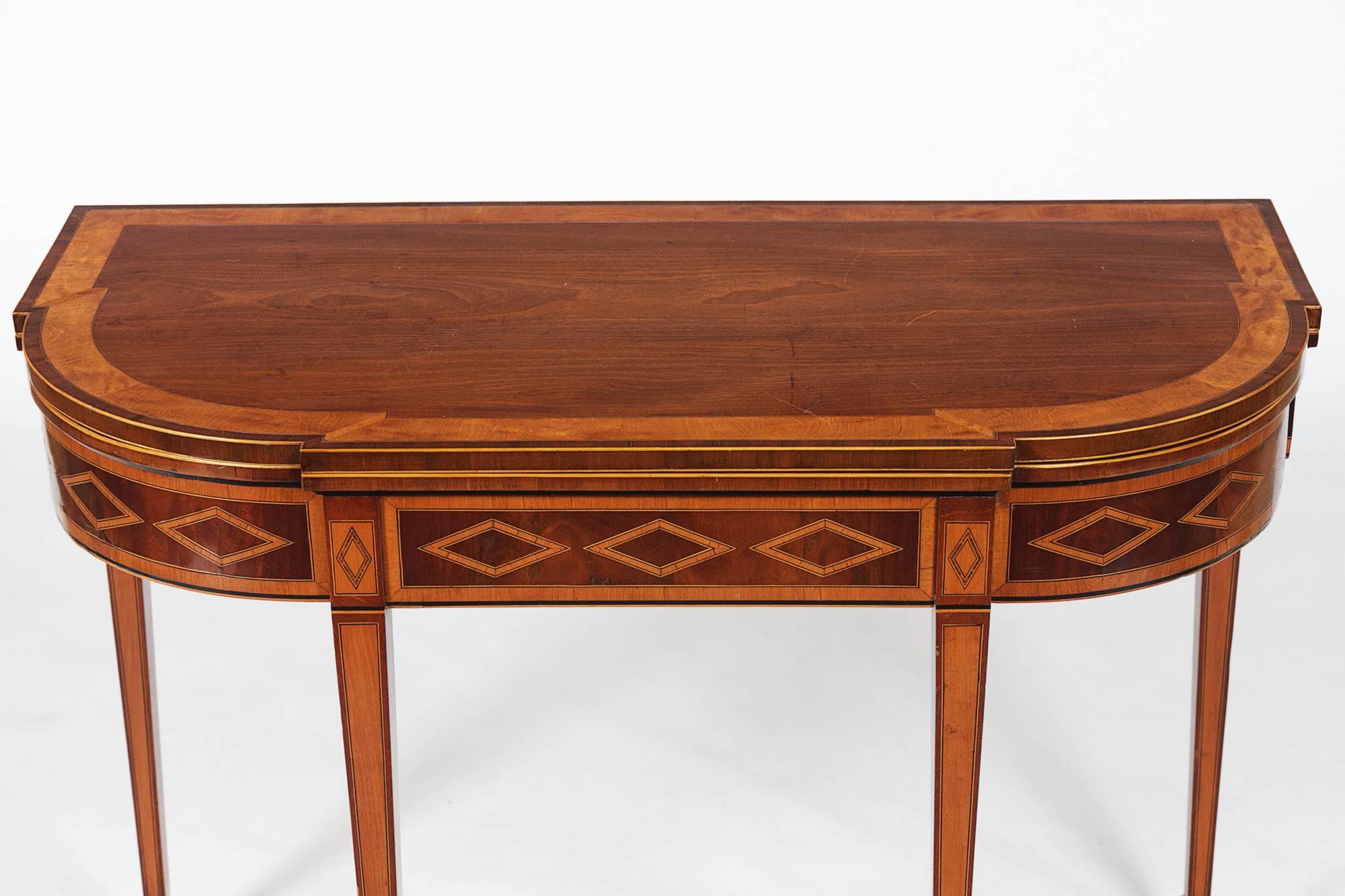 19th century mahogany breakfront D-shaped card table, the top and frieze with boxwood banding and ebony stringing. Raised on square tapering legs and spade feet.