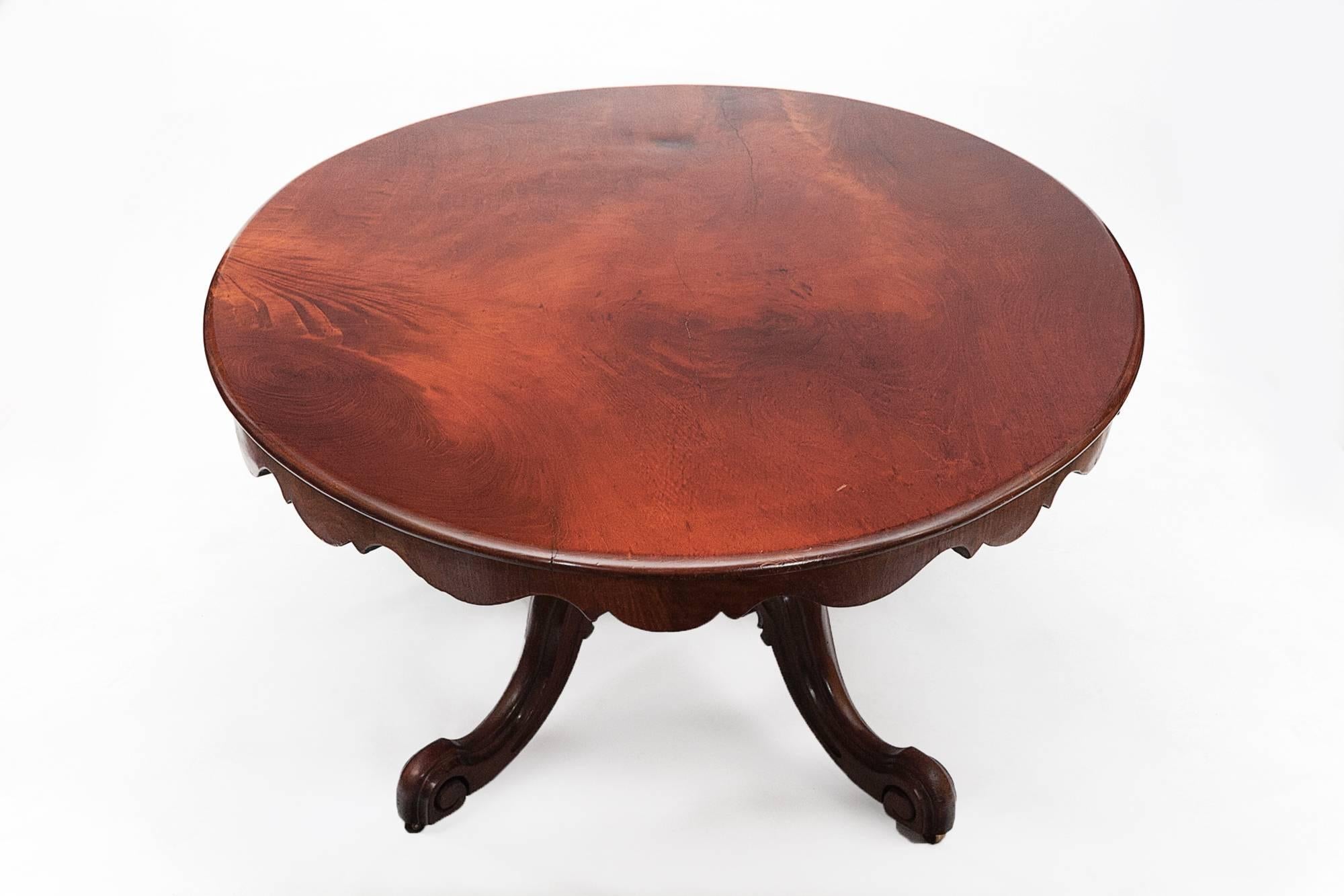 19th century mahogany oval tip-up supper table with moulded top and shaped apron raised on acanthus carved baluster pod and down swept legs and scrolled feet on casters.