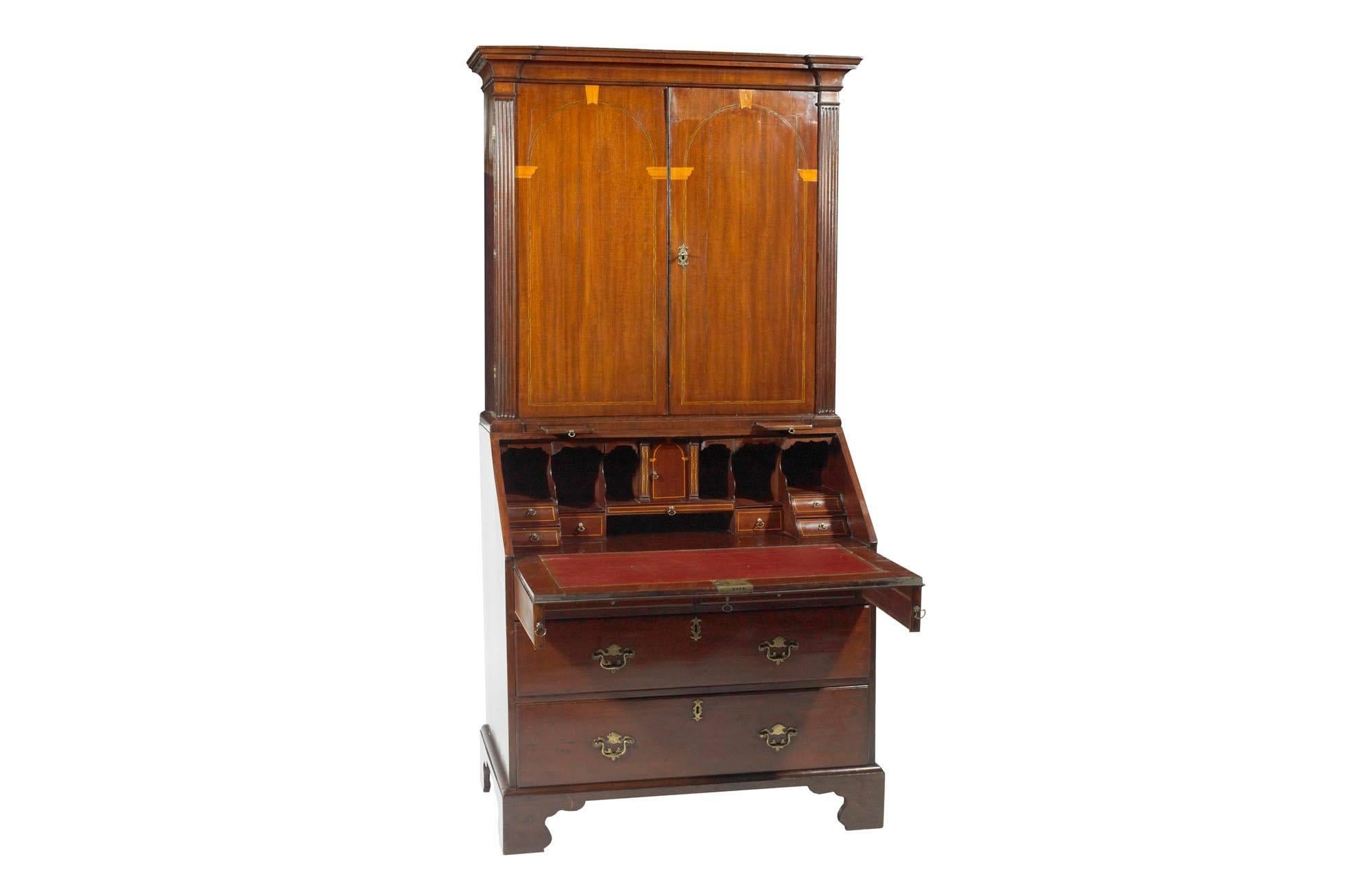 Early 19th Century George III mahogany inlaid bureau bookcase in the Neoclassical manner, the moulded and stepped cornice supported over two blind doors with Neoclassical architectural line inlay depicting classical column motif flanked with reeded
