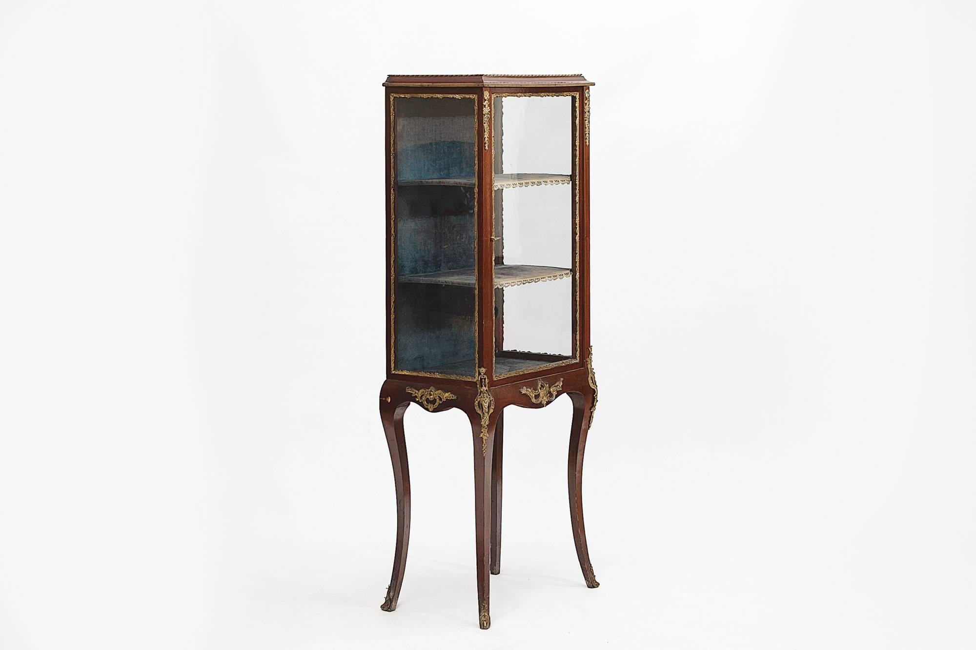 Vetrina in mogano in stile Regency francese del XIX secolo con montature in ottone; il mobile è dotato di due ripiani, l'interno è foderato in velluto e poggia su gambe a sciabola.