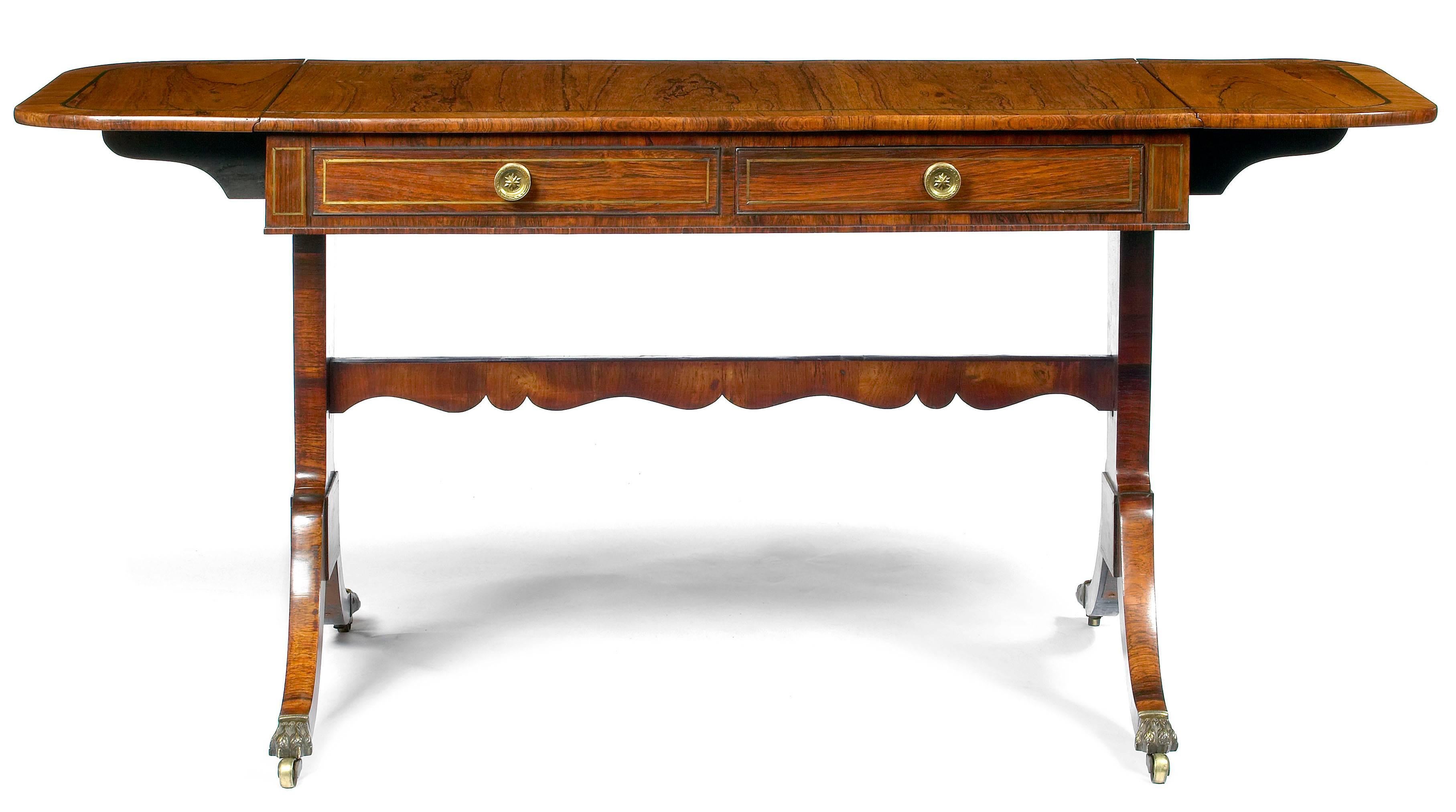 Early 19th Century Regency drop leaf sofa table in the manner of Thomas Sheraton, the moulded top of rectangular form with rounded corners and fine brass line inlay raised over a pair of cockbeaded and brass inlaid frieze short drawers with