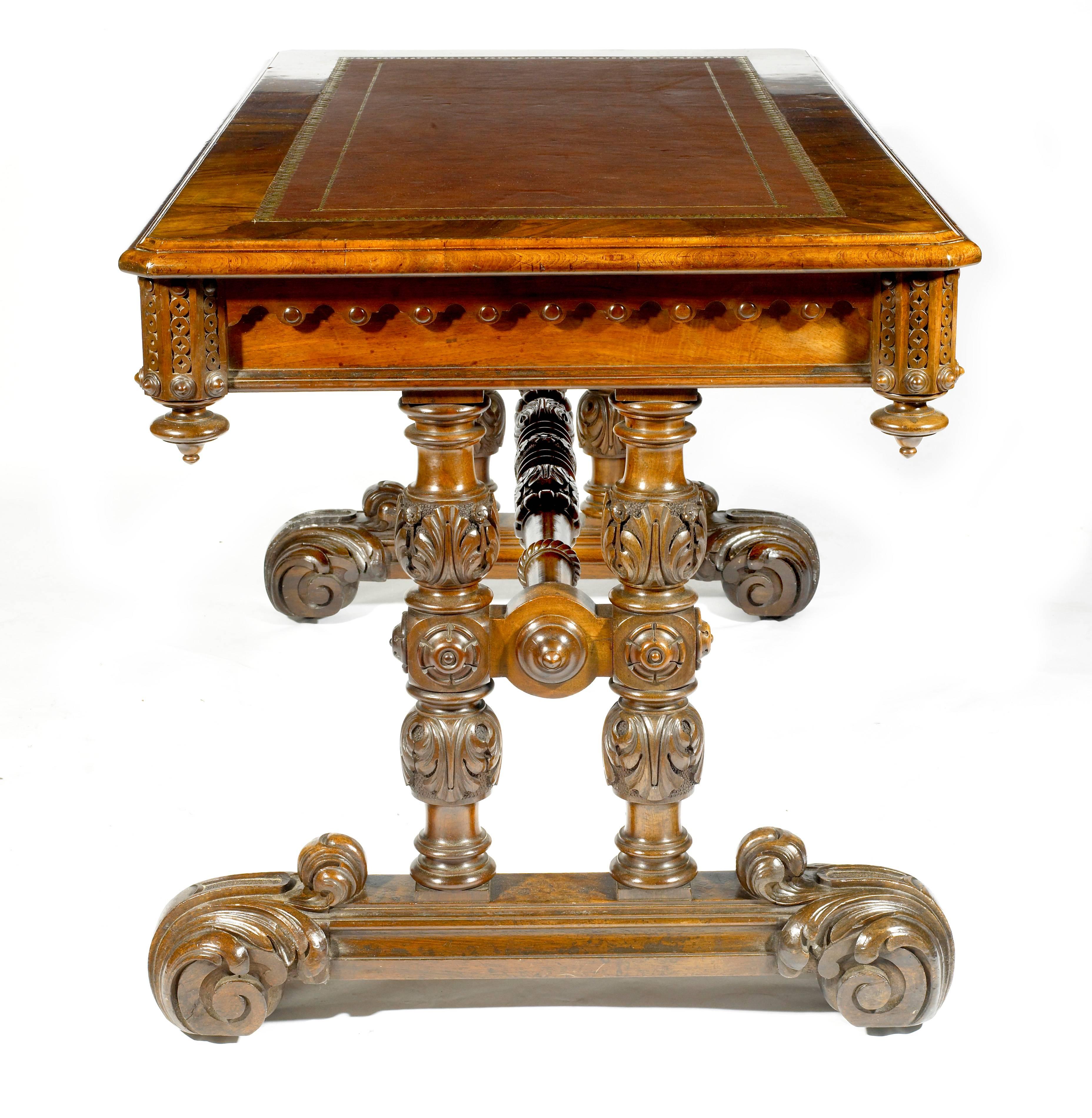 Early 19th century William IV walnut library table. The rectangular top with a tooled leather inset above a frieze enclosing two drawers. The heavily carved end supports joined by a carved and turned stretcher on carved platform bases on castors.