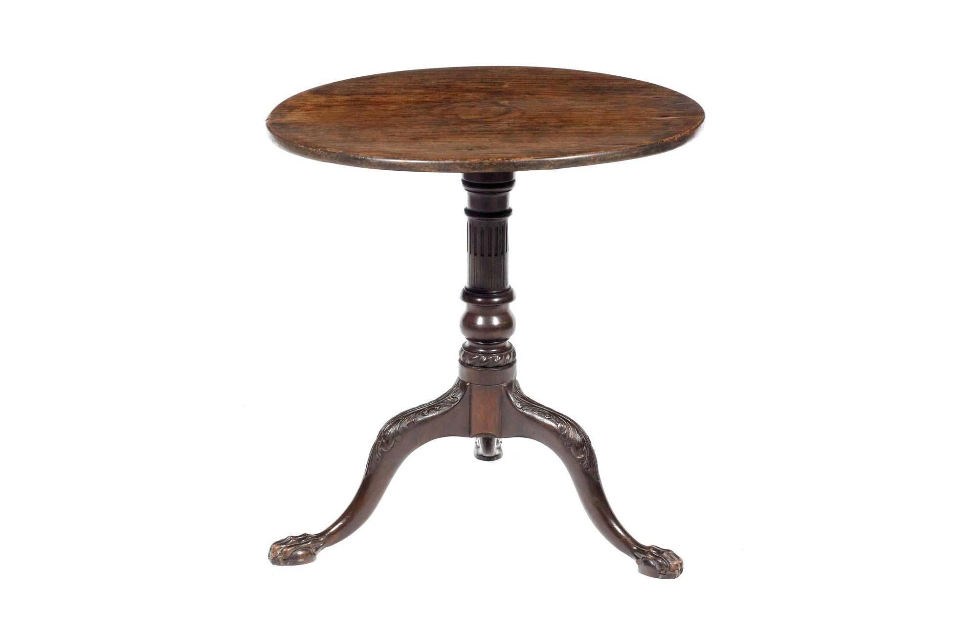 19th century George III mahogany tilt-top occasional circular table. The top on a gun barrel column, supported on three carved legs and claw feet.