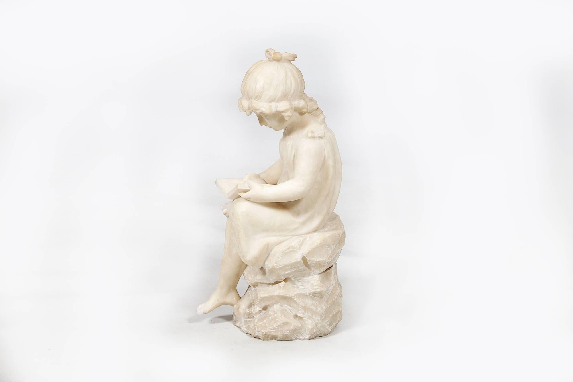 19th century white marble statue of a young girl sitting reading.