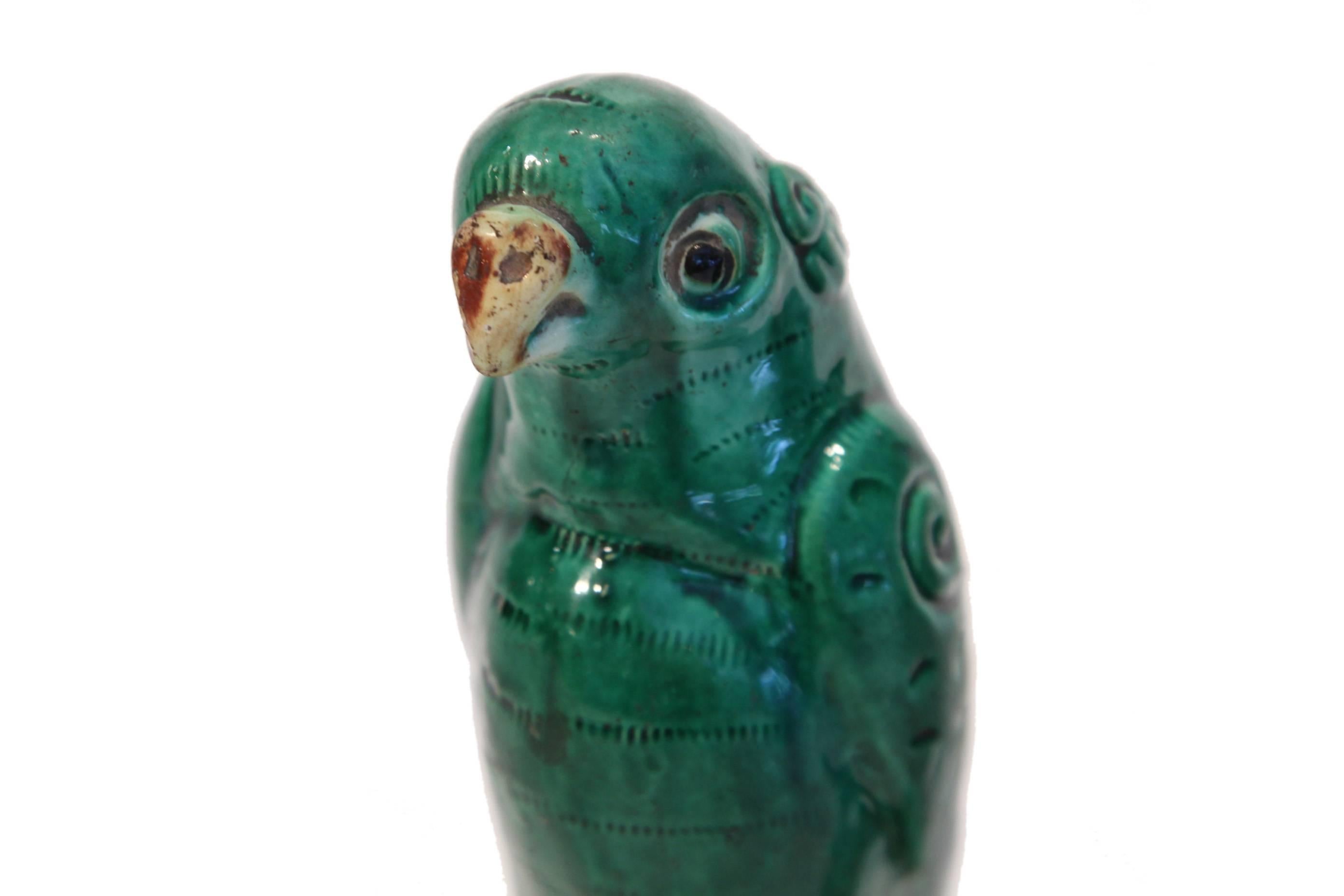 Early 19th century pair of ceramic incense burners in the form of parrots perched on a stone in green glaze, circa 1800.