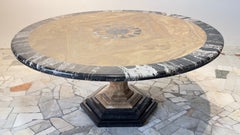 Importante mesa redonda de ónix y mármol negro Marquina con incrustación en forma de sol