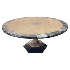 Importante mesa redonda de ónix y mármol negro Marquina con incrustación en forma de sol