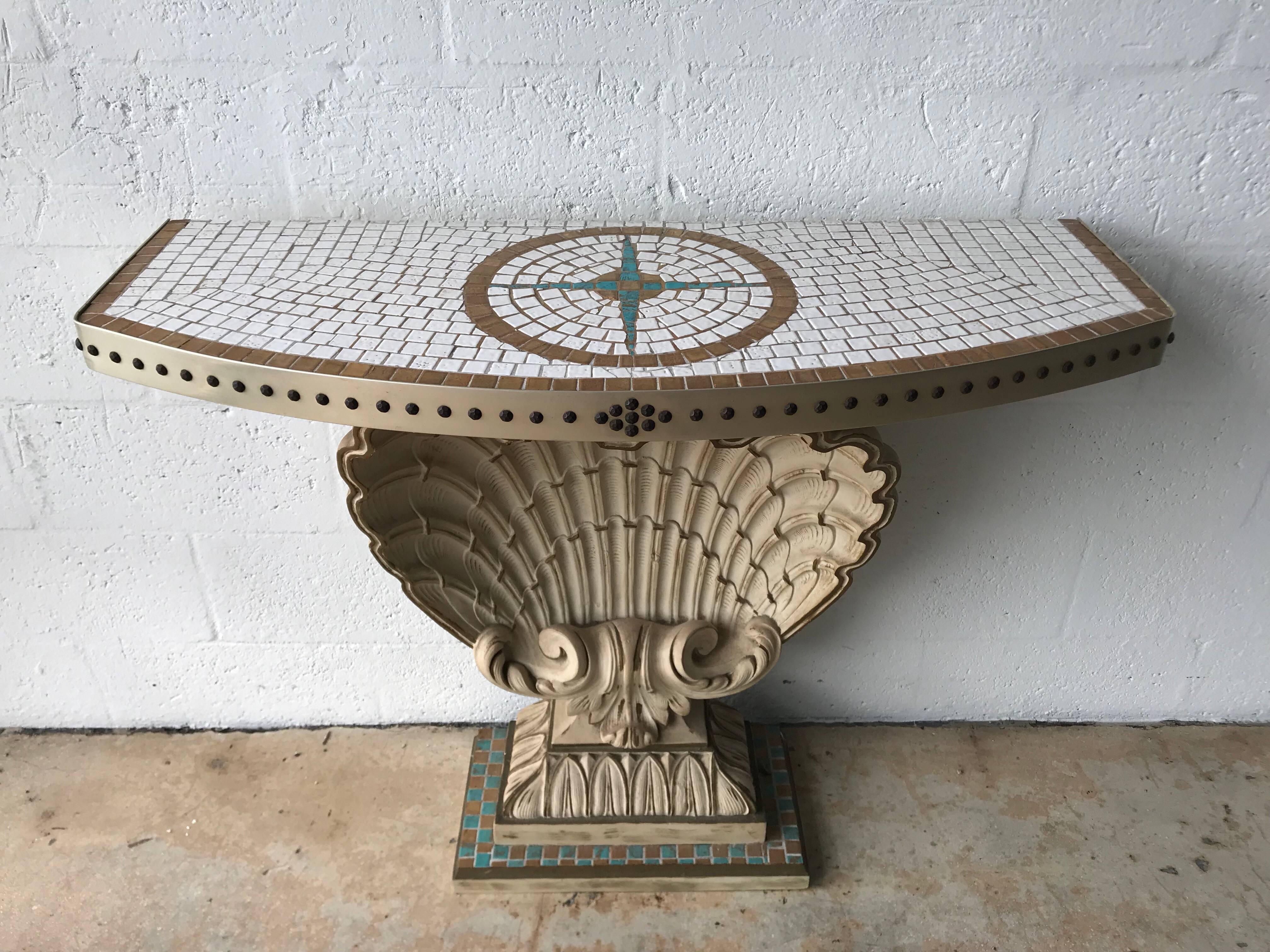 Hollywood Regency carved shell demi-lune console by Maison Jansen, with gilt carved wood, and a ceramic tiled top wrapped with a steel banding and bronze studs