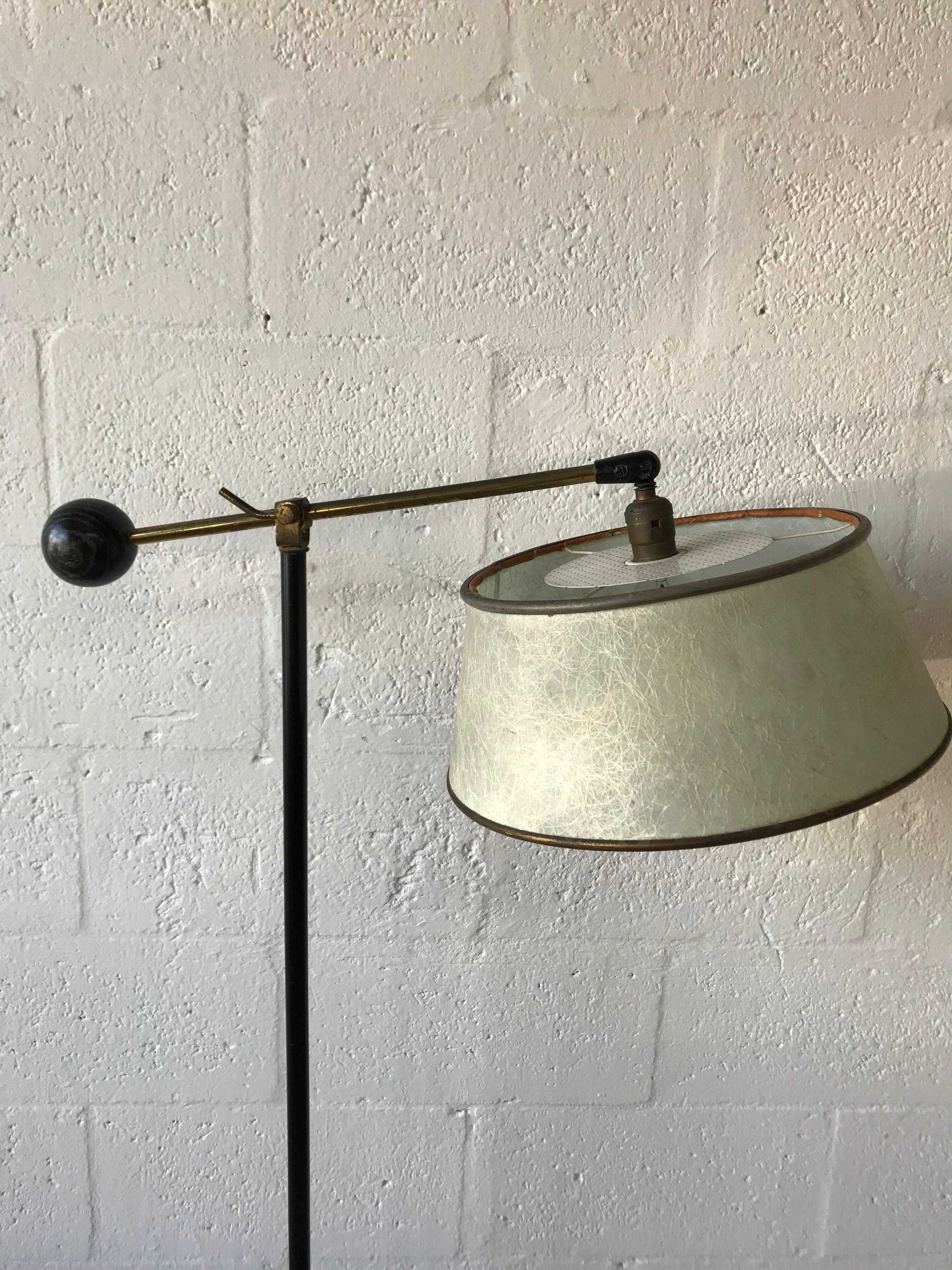 Art Deco reading or floor lamp rendered in patinated brass with an adjustable arm, original fiberglass shade with perforated diffuser and a large ebonized and cerused oak ball on the opposing side.